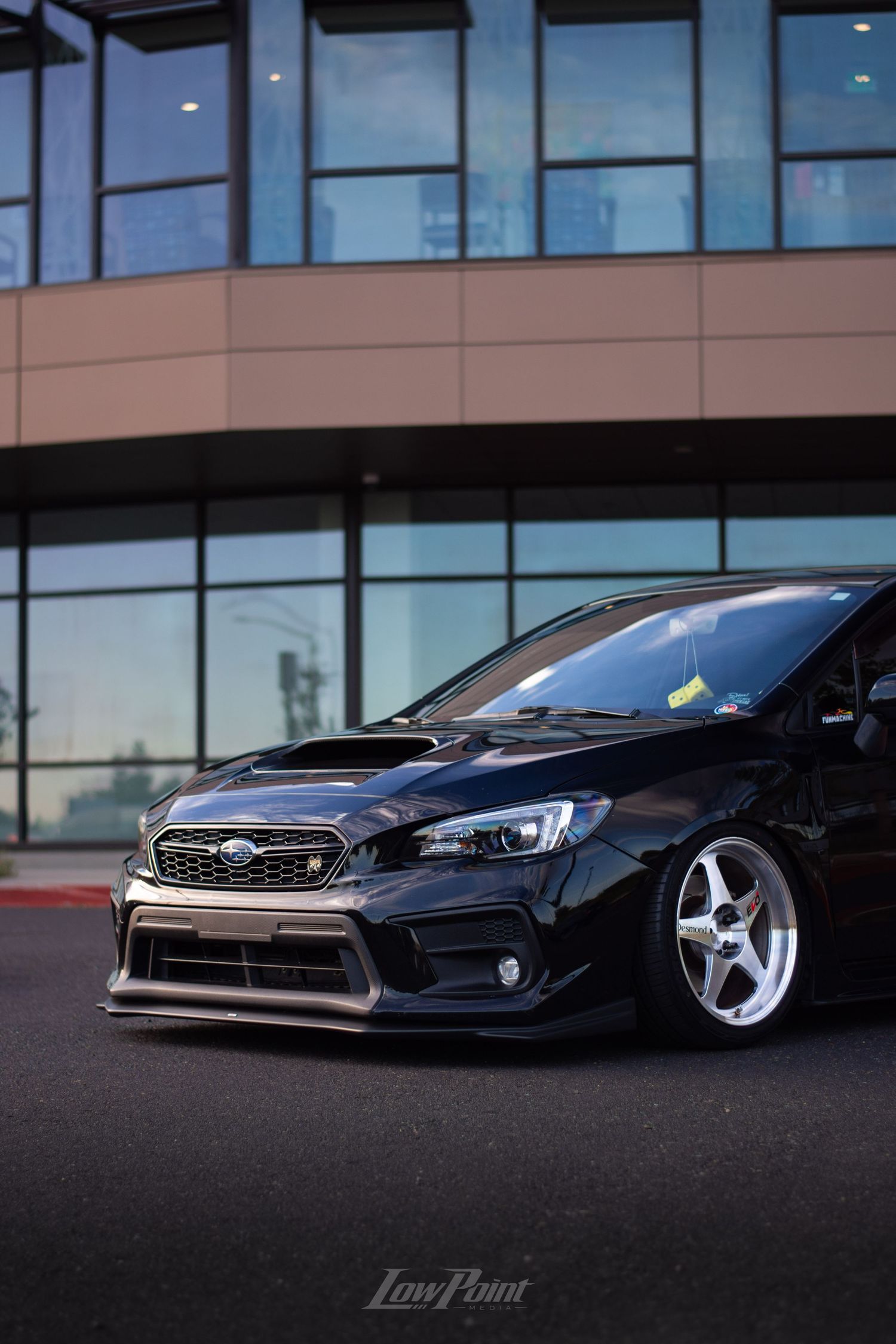 Black Subaru WRX photographed in front of modern building with large modern windows
