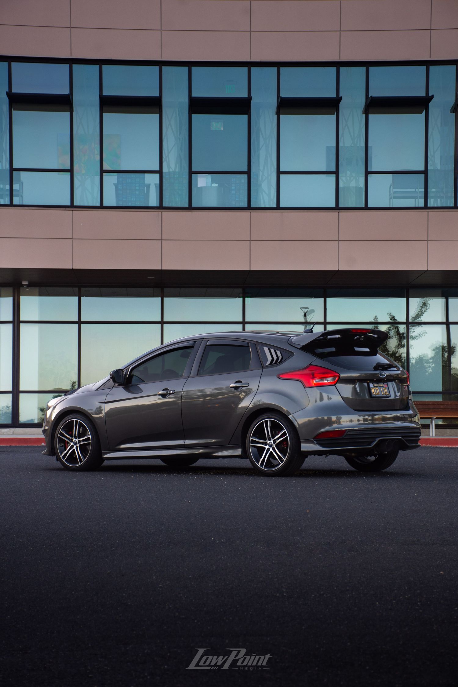 Magnetic Grey Ford Focus ST photographed in front of modern building with large windows