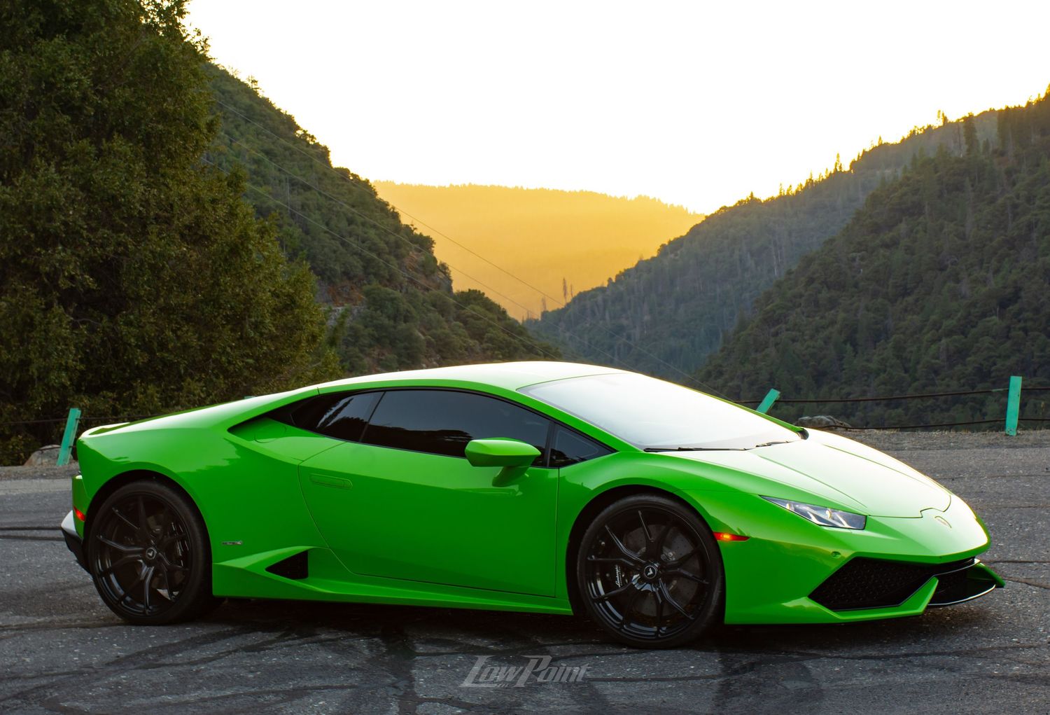 Green Lamborghini Huracan photographed with golden sunset mountains in the background