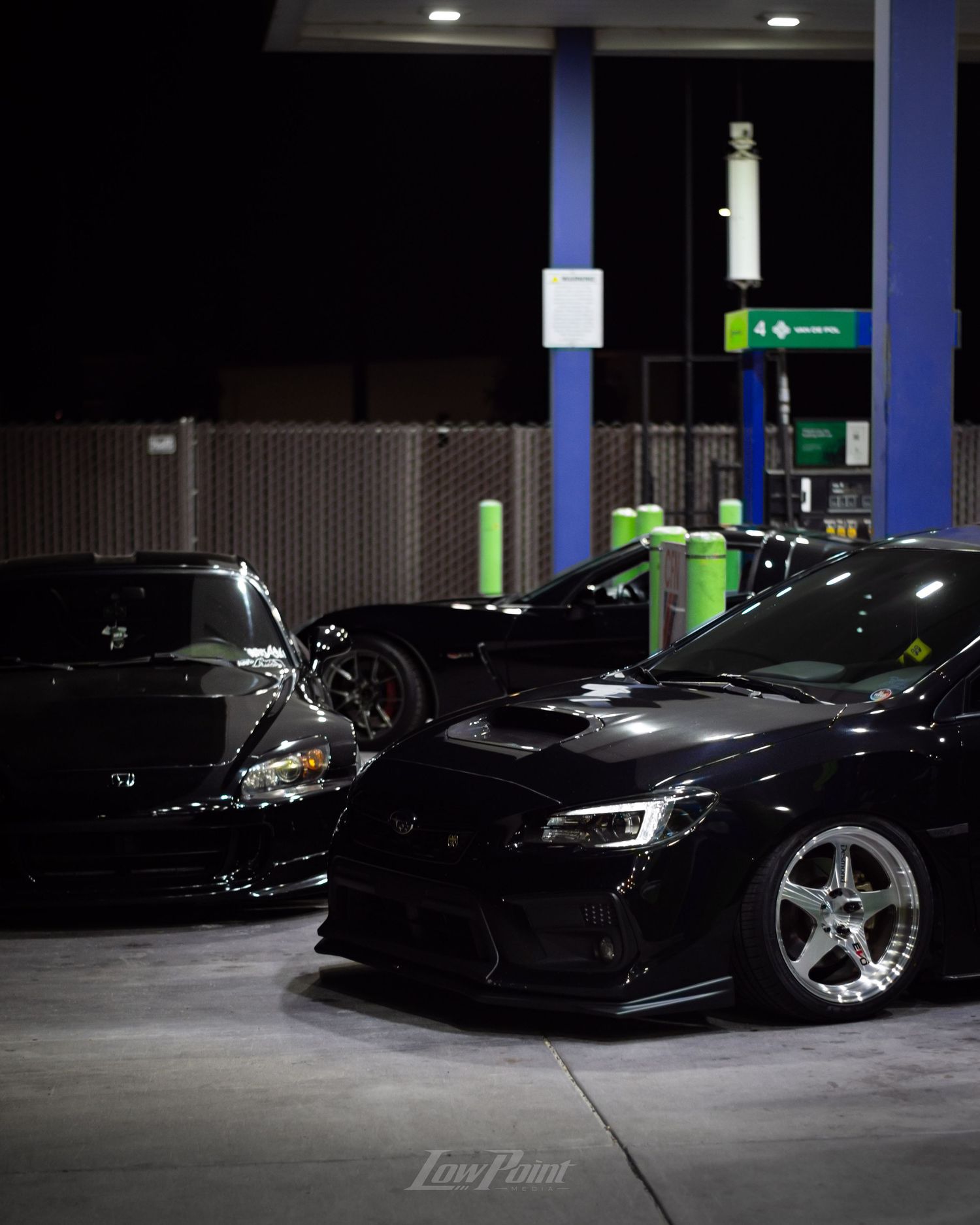 Black Honda S2000 photographed at night at a gas pump with white Work wheels