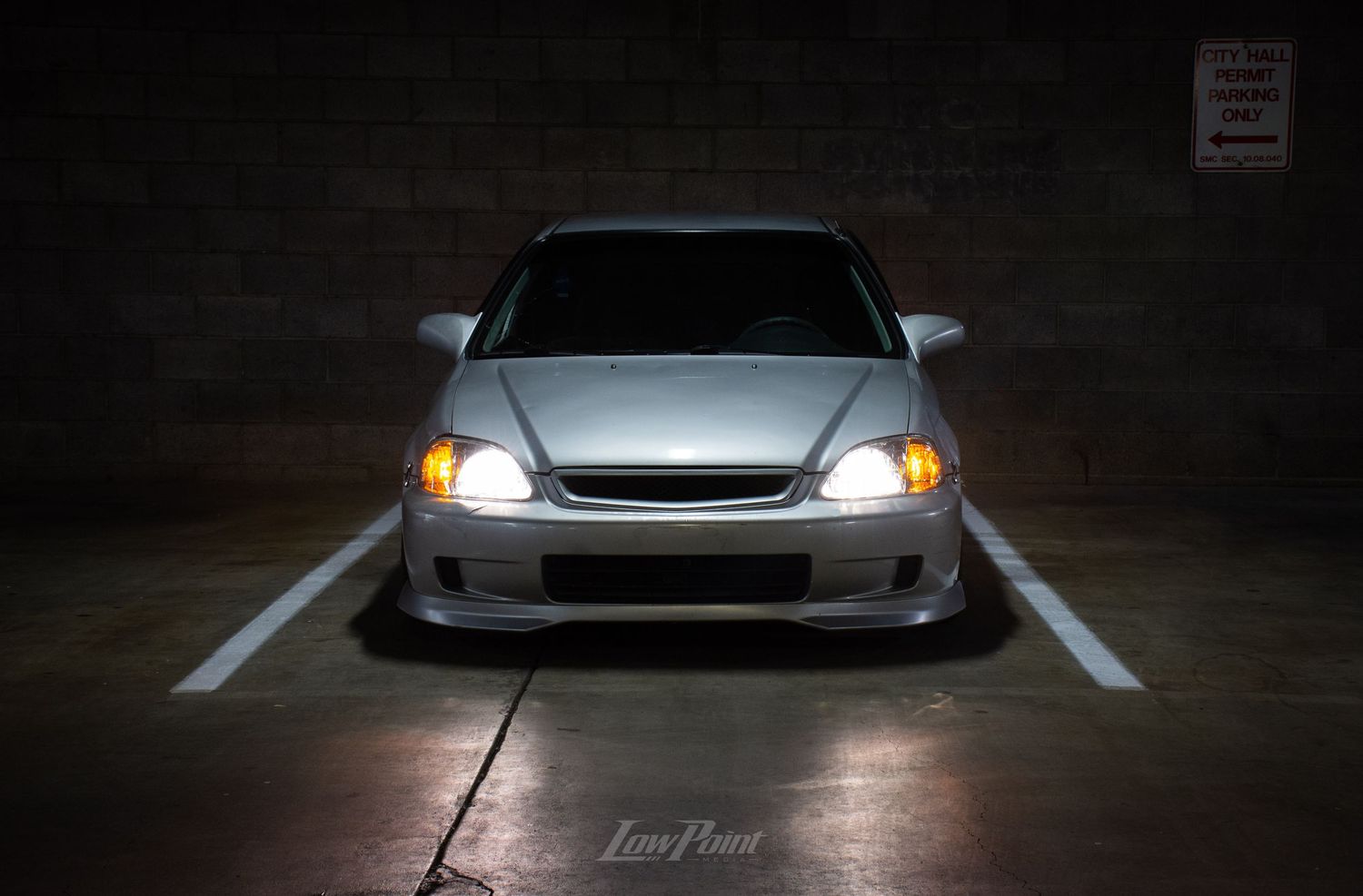 Silver Honda Civic photographed in parking garage at night with moody lighting