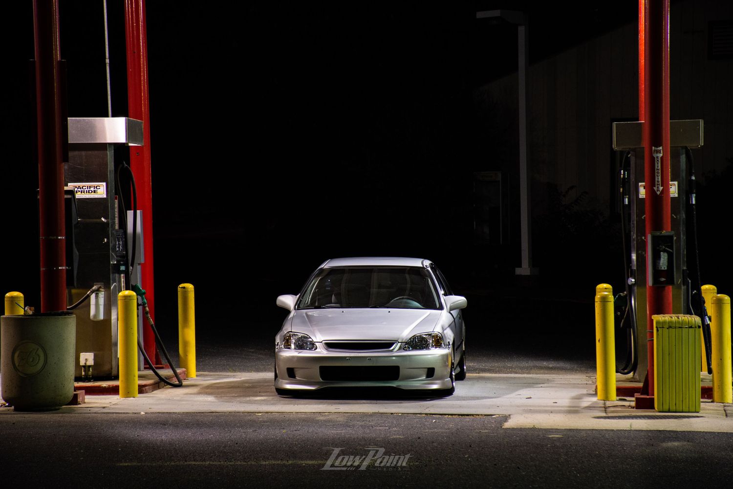 Silver Honda Civic photographed at a gas station pump at night