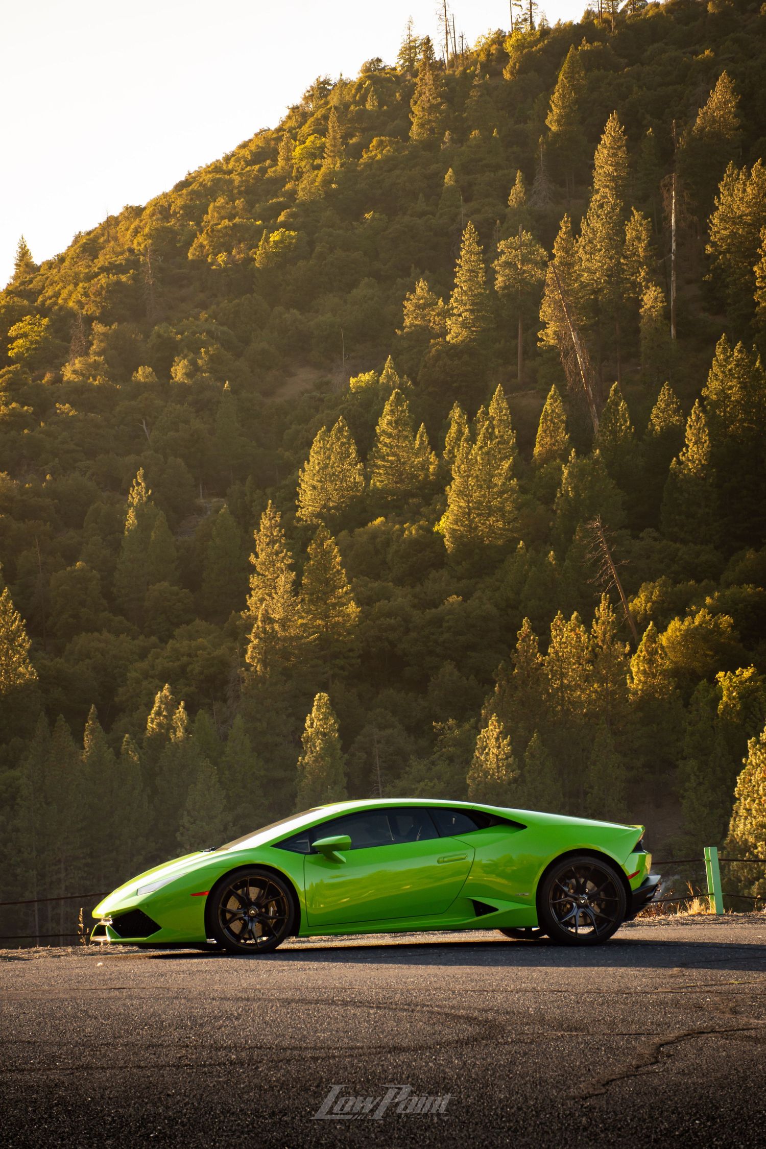 Green Lamborghini Huracan photographed with golden sunset mountains in the background
