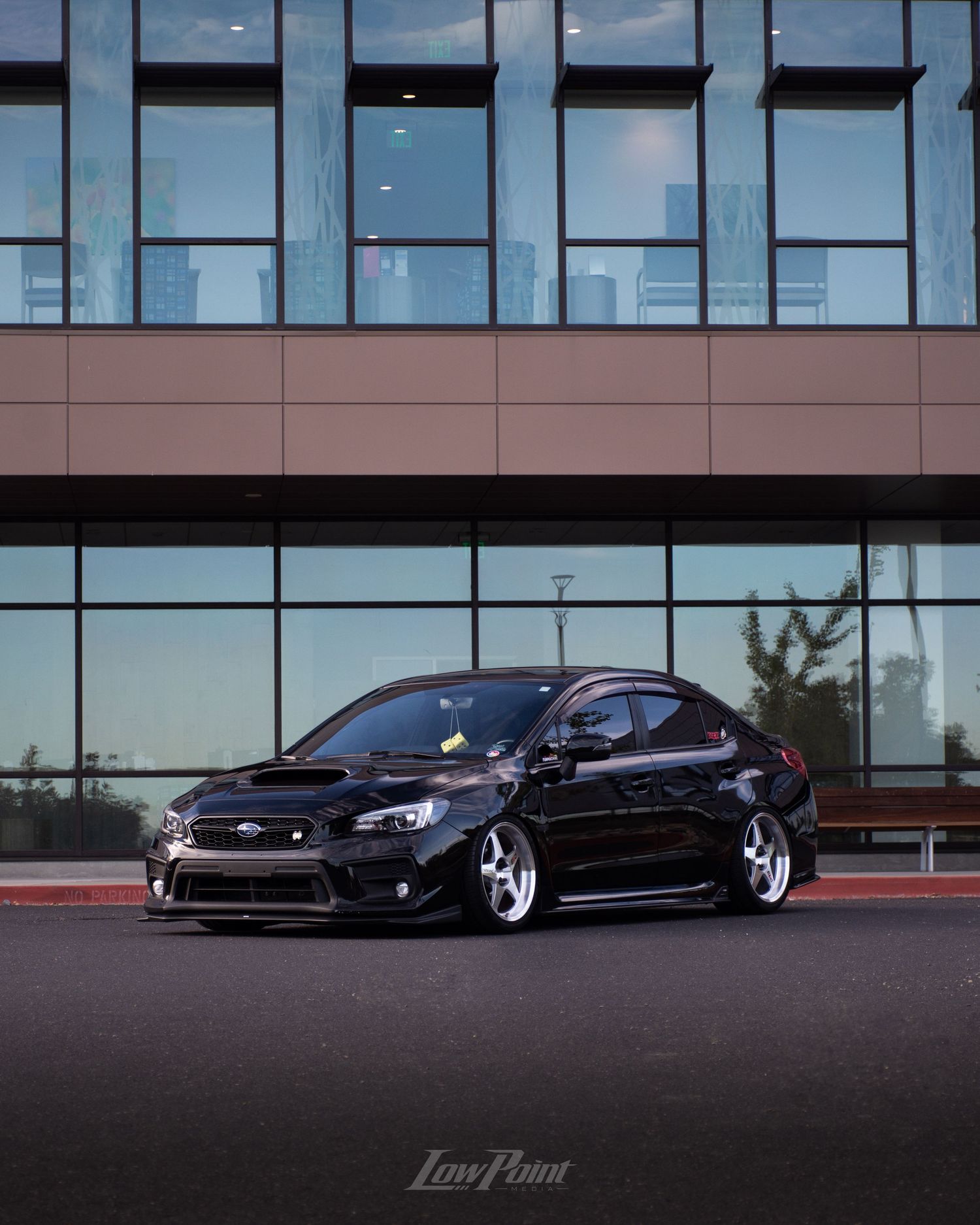 Black Subaru WRX photographed in front of modern building with large modern windows
