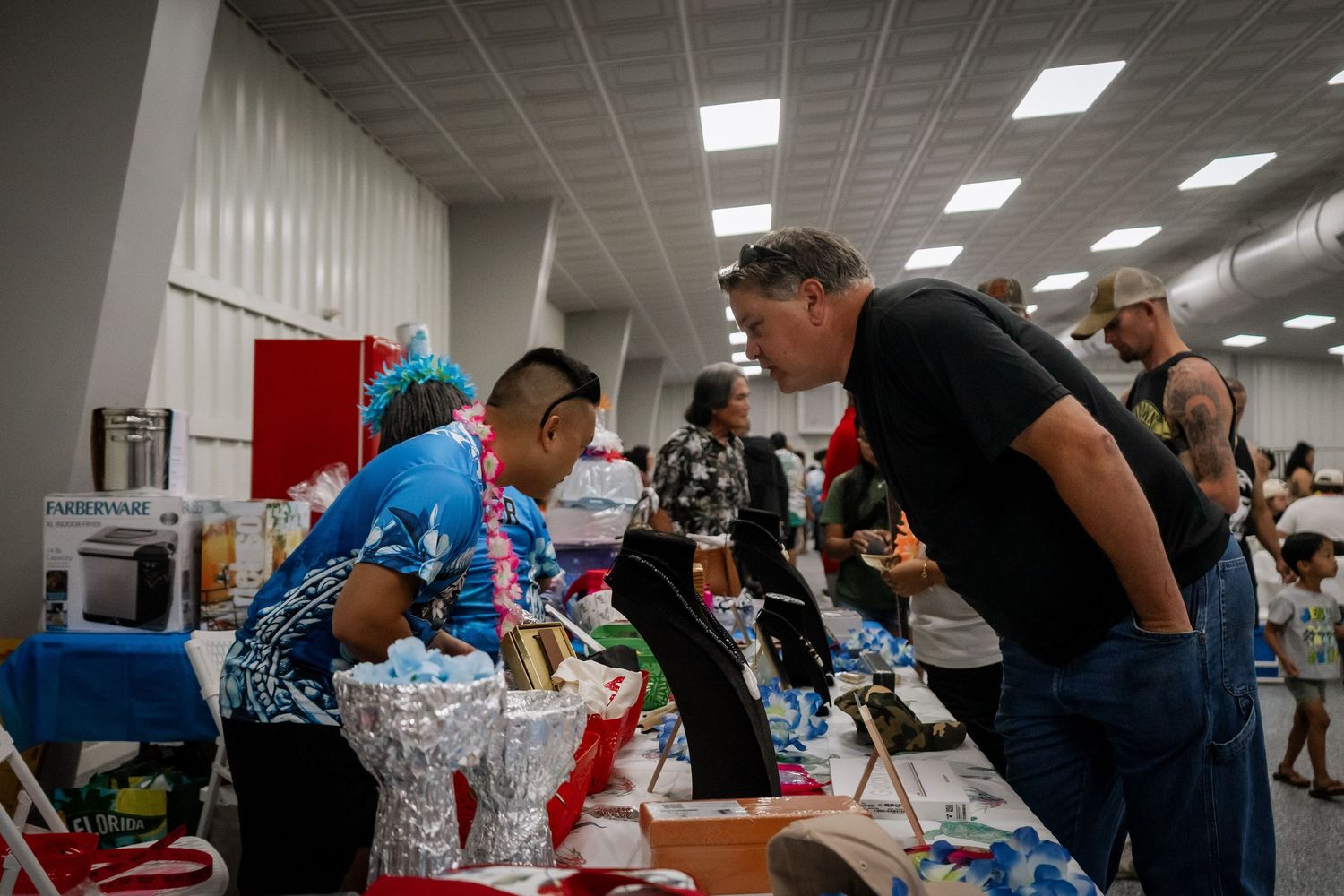 Attendees browse gift items and prizes at an indoor cultural community event.