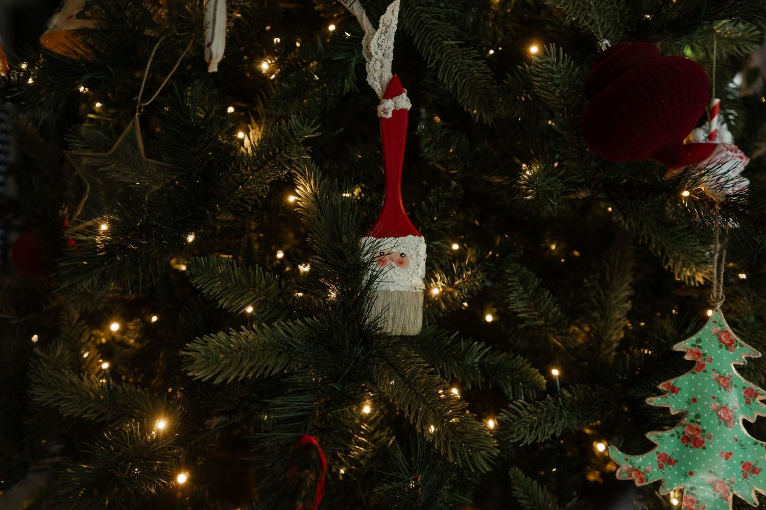 A decorated Christmas tree with Santa Claus ornaments and warm twinkling lights.