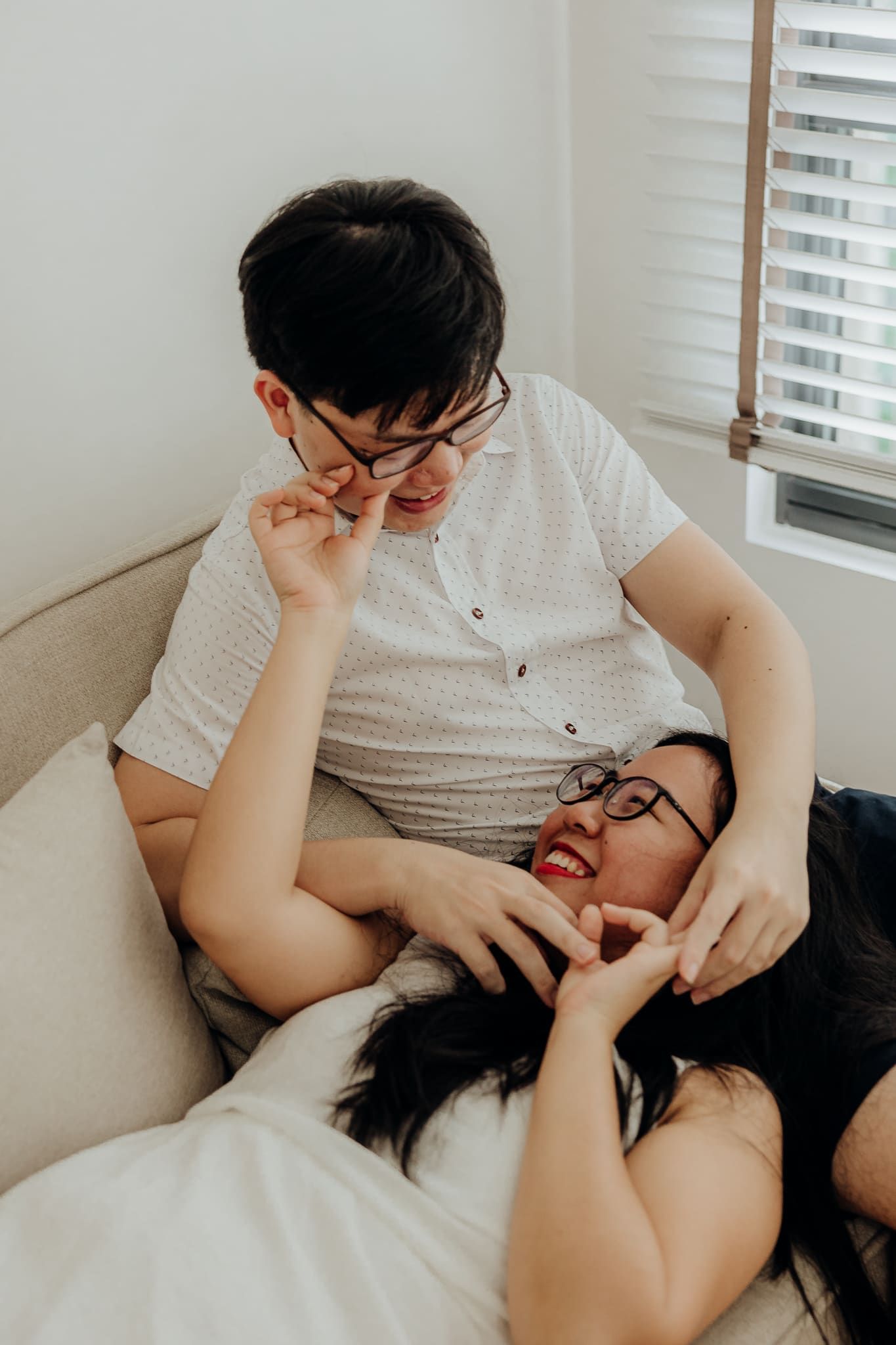 Playful interaction captured in a series of candid moments on a light colored sofa.