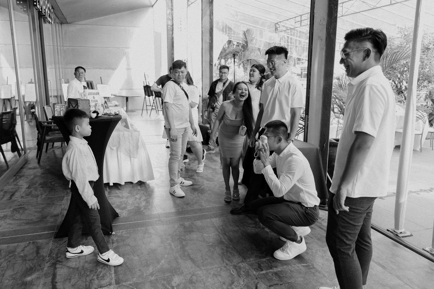 Behind the scenes look at photographers at work during a wedding on a covered outdoor patio.