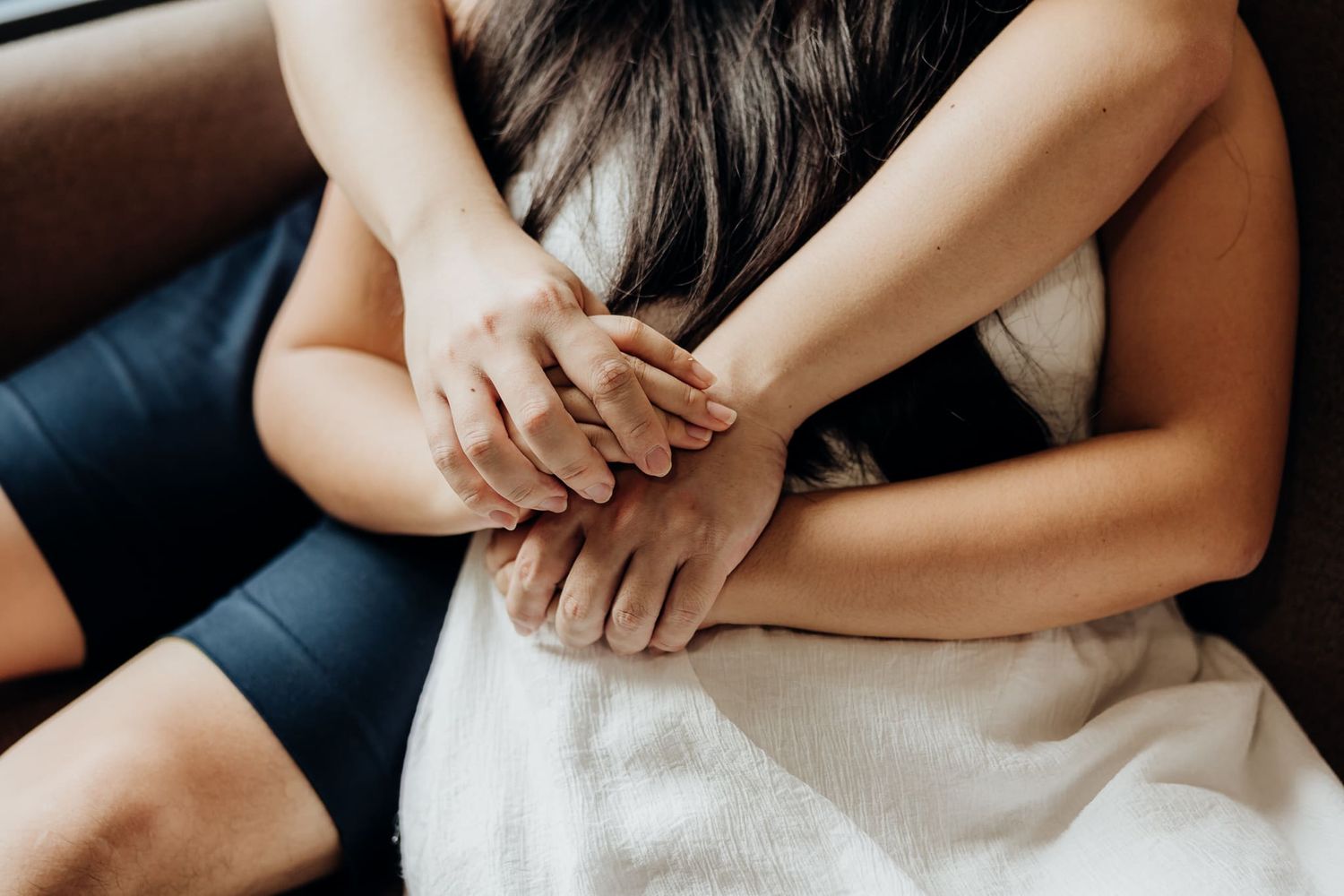 Close-up details of couple's hands and intimate moments on sofa.