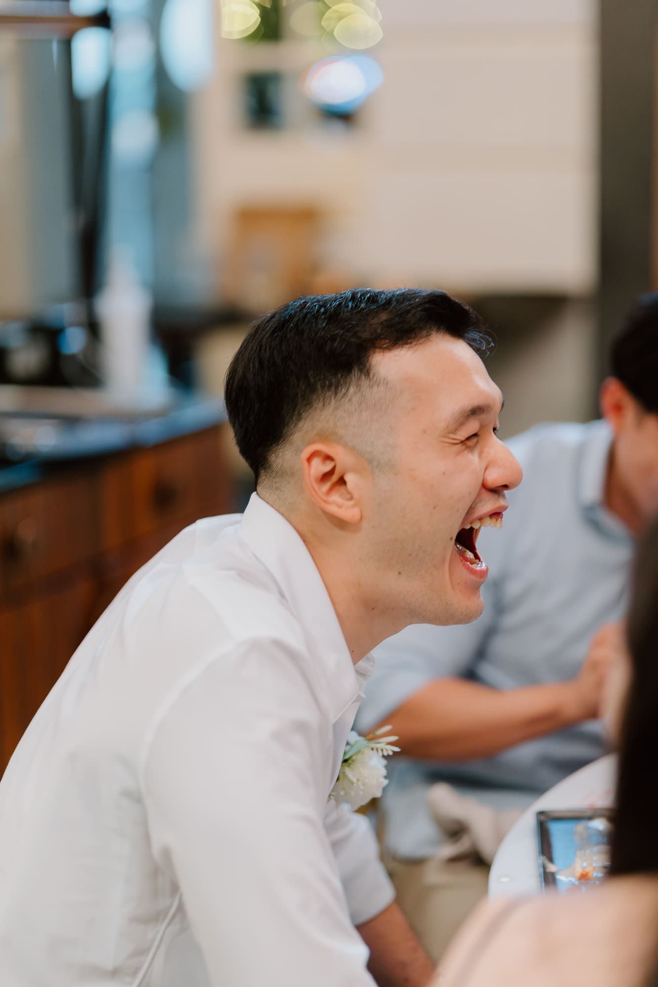 A sequence of photos showing someone in a white dress shirt laughing joyfully at a social gathering.
