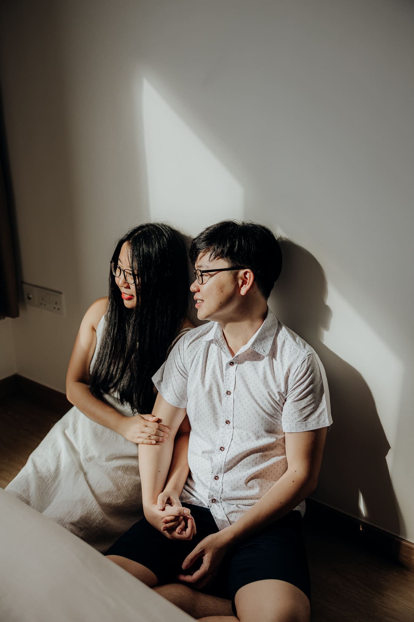Artistic shadow play photographs capturing intimate moments against a white wall.