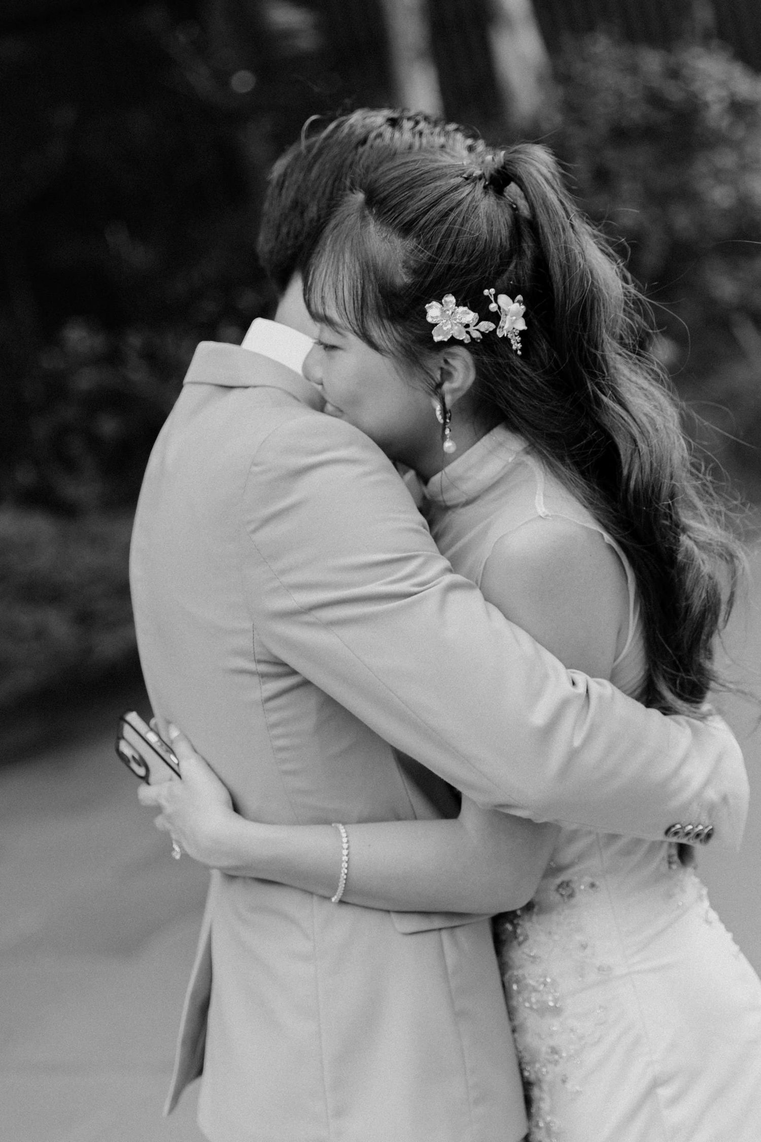 Black and white photo of a couple sharing a romantic embrace at their wedding ceremony.