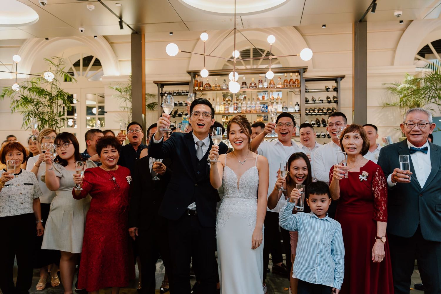 A sequence of lively wedding reception photos showing guests clapping and dancing in a modern indoor venue with white decor.
