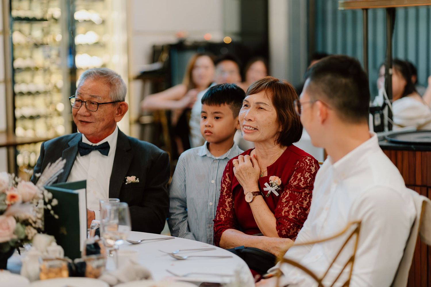Family gathered around a table at an elegant restaurant during a special occasion dinner.