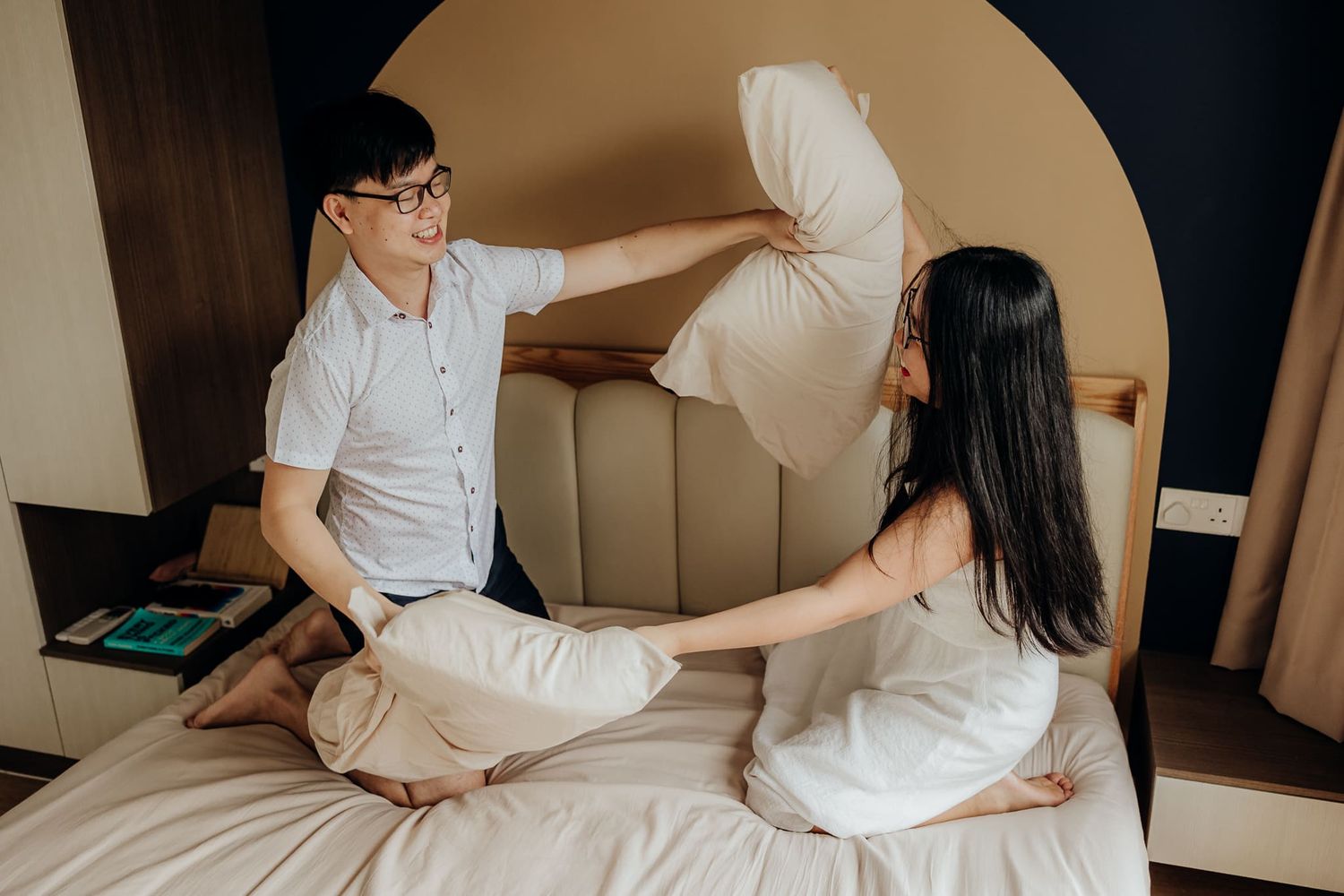 Two people sitting intimately on white furniture while having a conversation.
