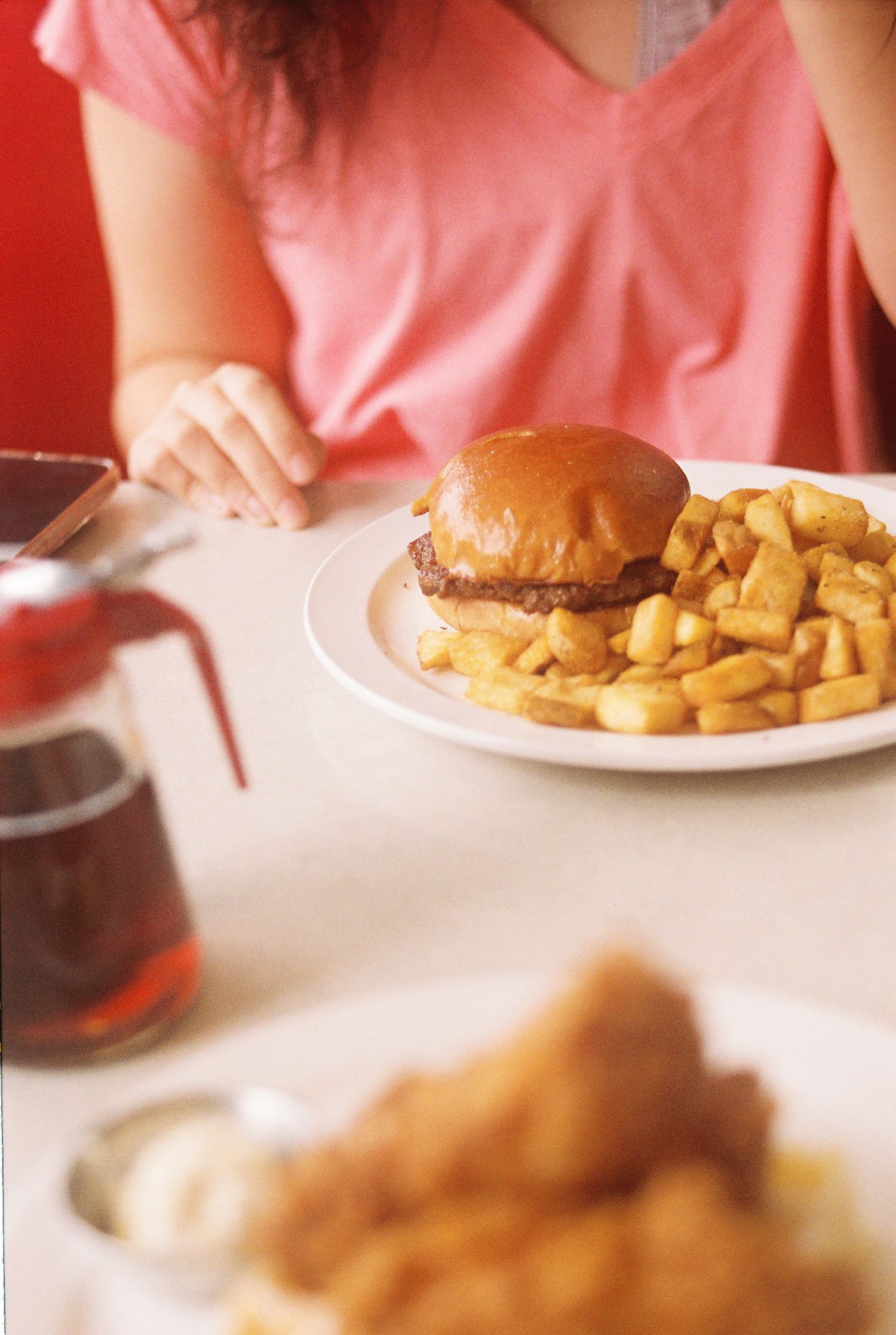 At The Corner's burger and fries with syrup and chicken and waffles off to the side.
