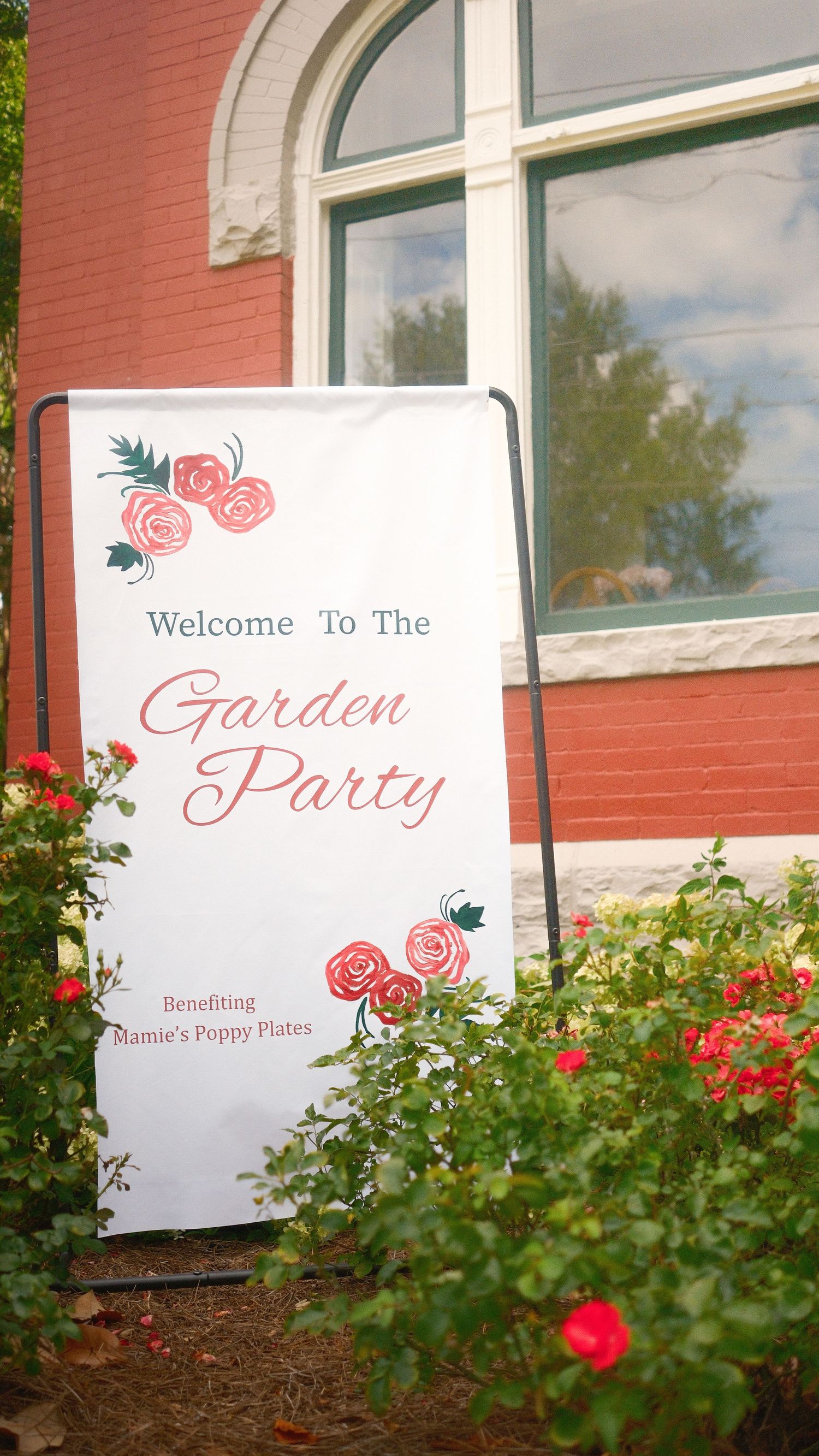 An event banner in a garden.