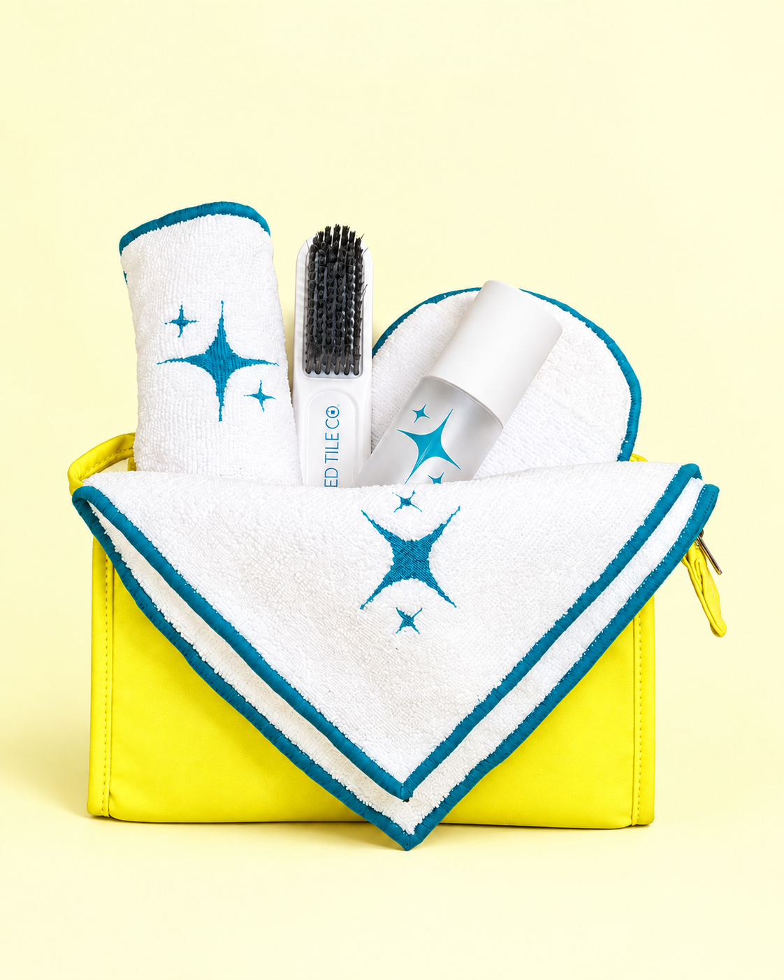 A studio product photo of a cleaning kit with a light yellow backdrop.