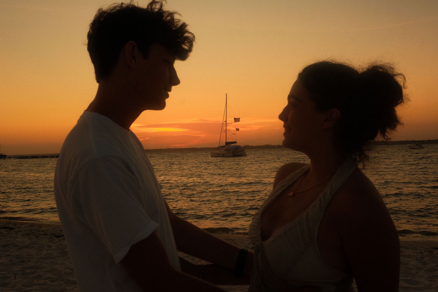 Sawyer and Fiona looking at each other on the beach at sunset.