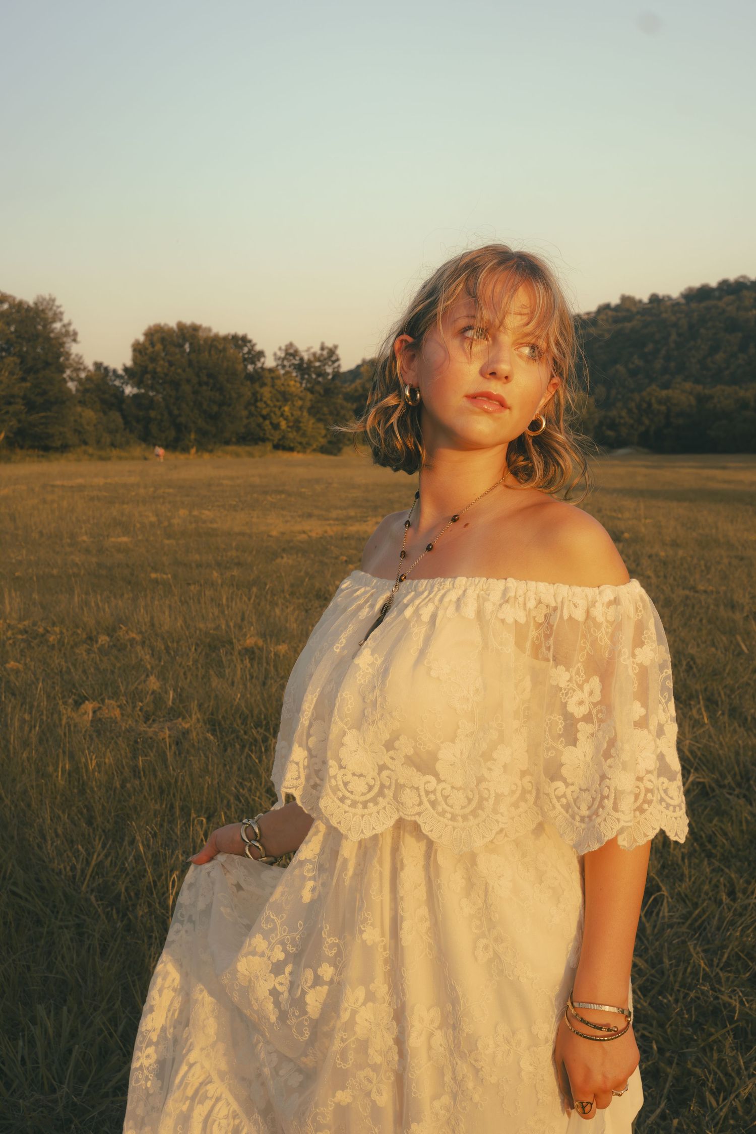 Caroline in a white dress in a field.