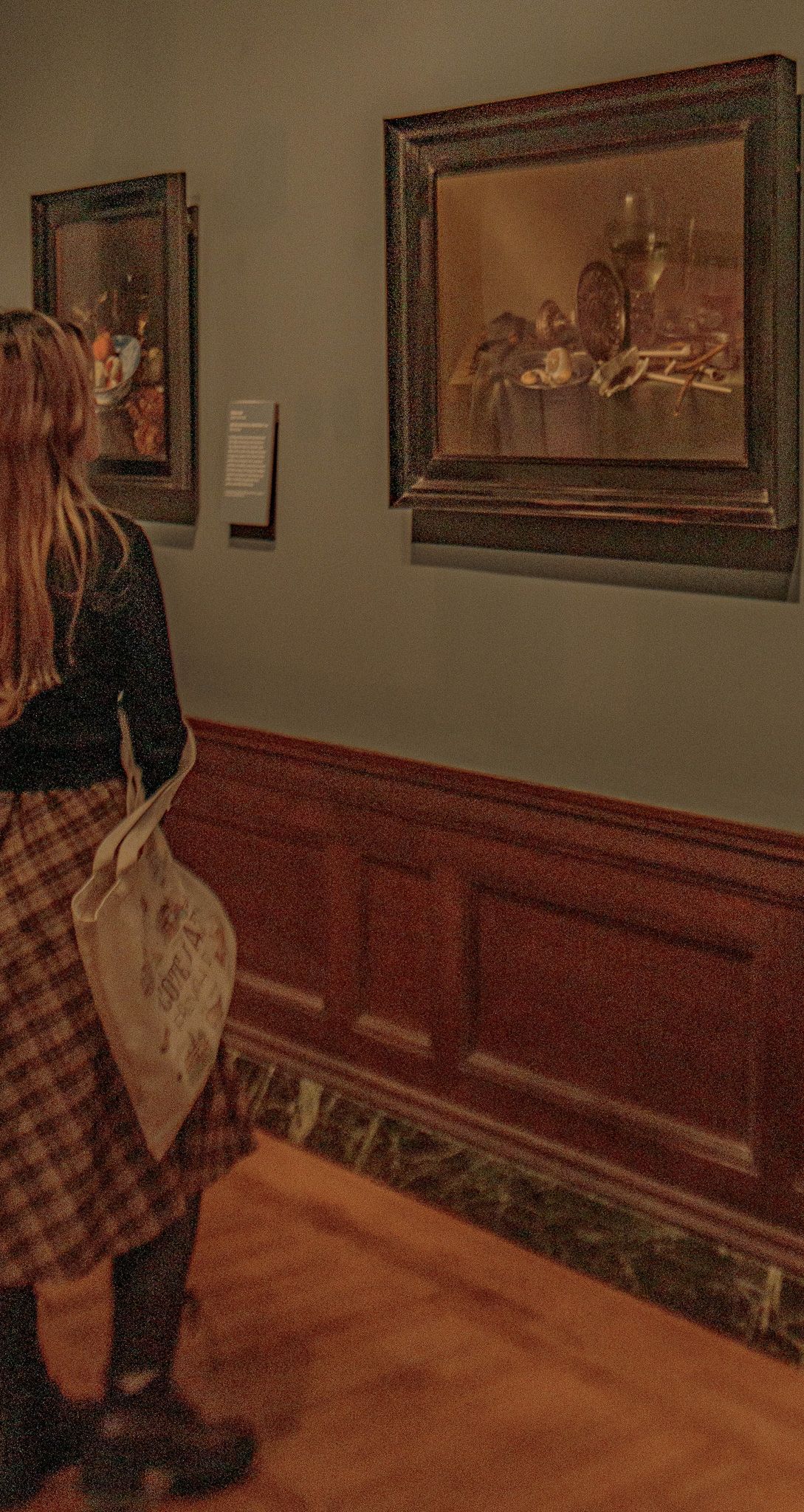 A candid moment of a woman appreciating a painting, capturing a genuine sense of wonder and admiration