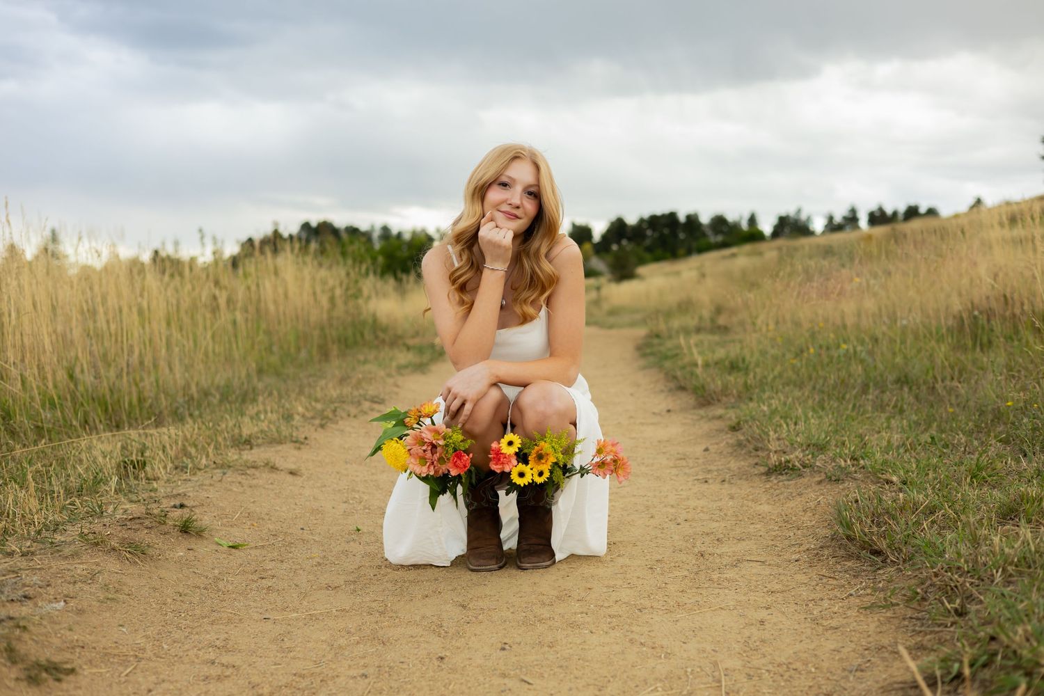 Outdoor photoshoot in a golden wheat field with mountain backdrop.