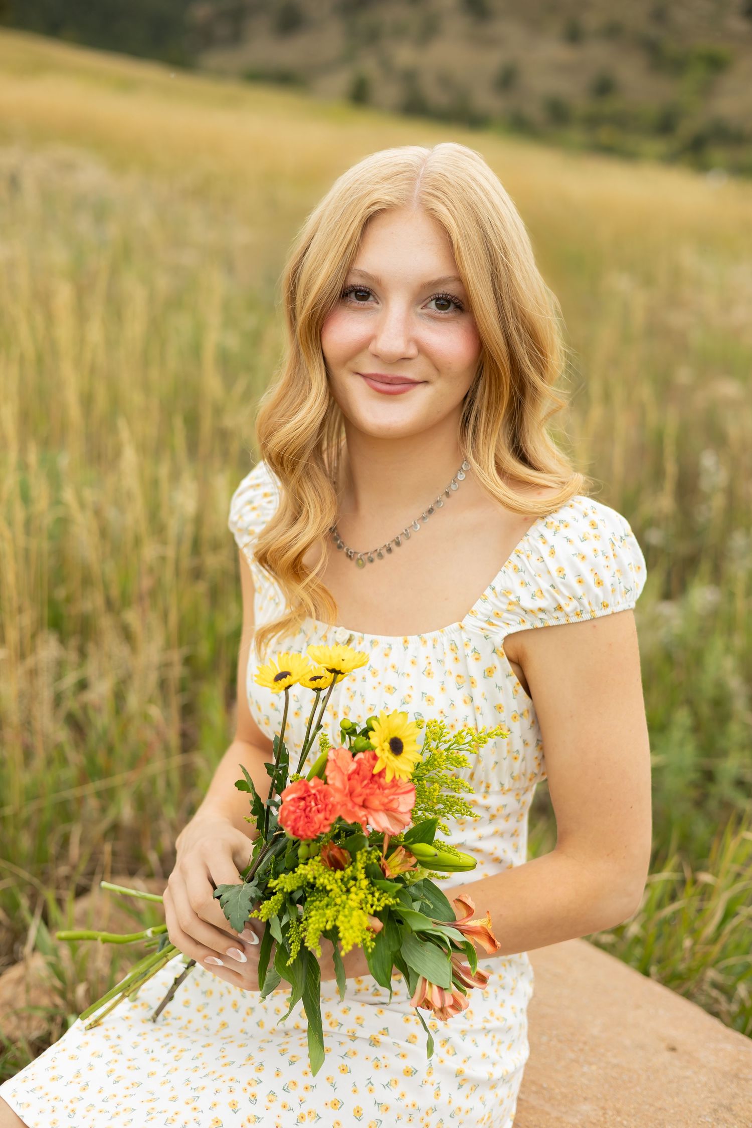 Summer portrait with bright sunflower bouquet against mountain landscape.
