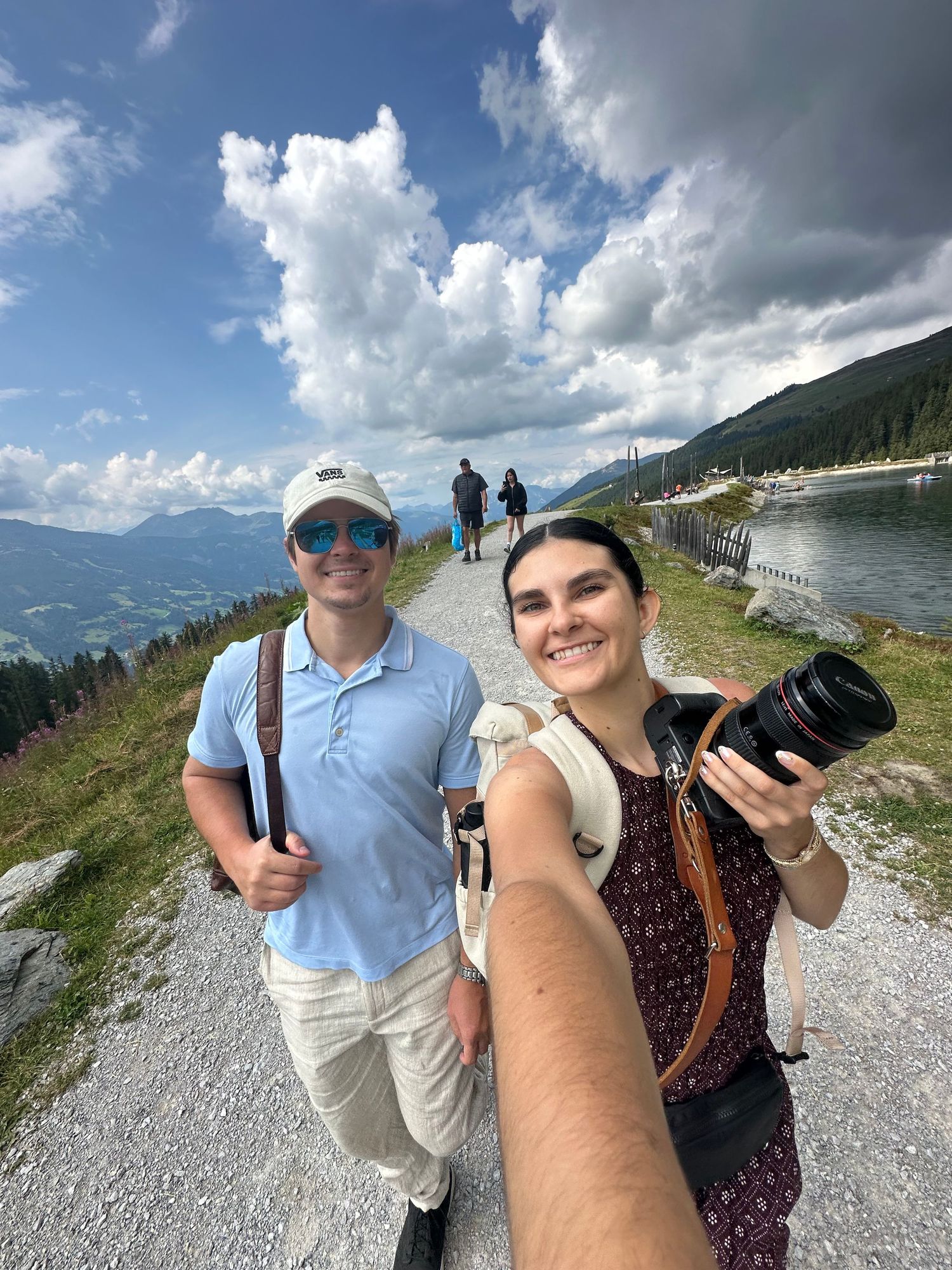 Hiking group taking selfies on a mountain trail with scenic views.