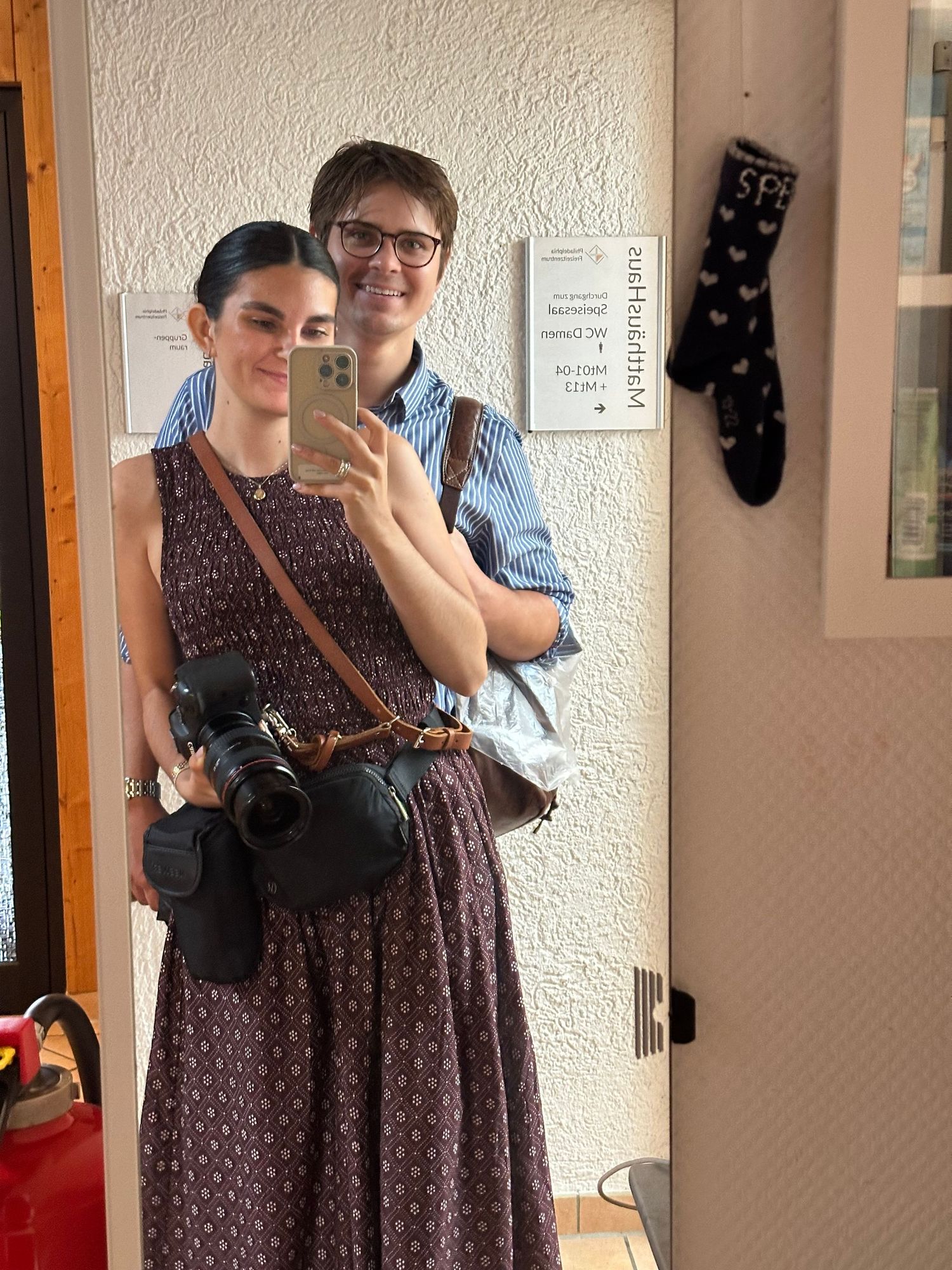 Interior mirror reflection showing travel companions in casual attire.