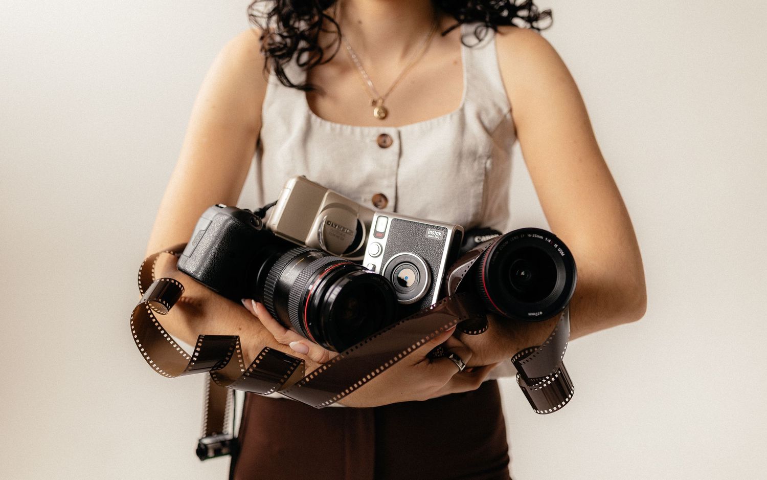 Vintage cameras and photography equipment arranged on neutral background.