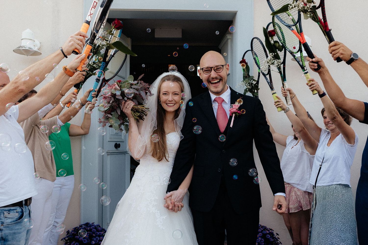 Wedding celebration with guests raising champagne glasses in celebration.