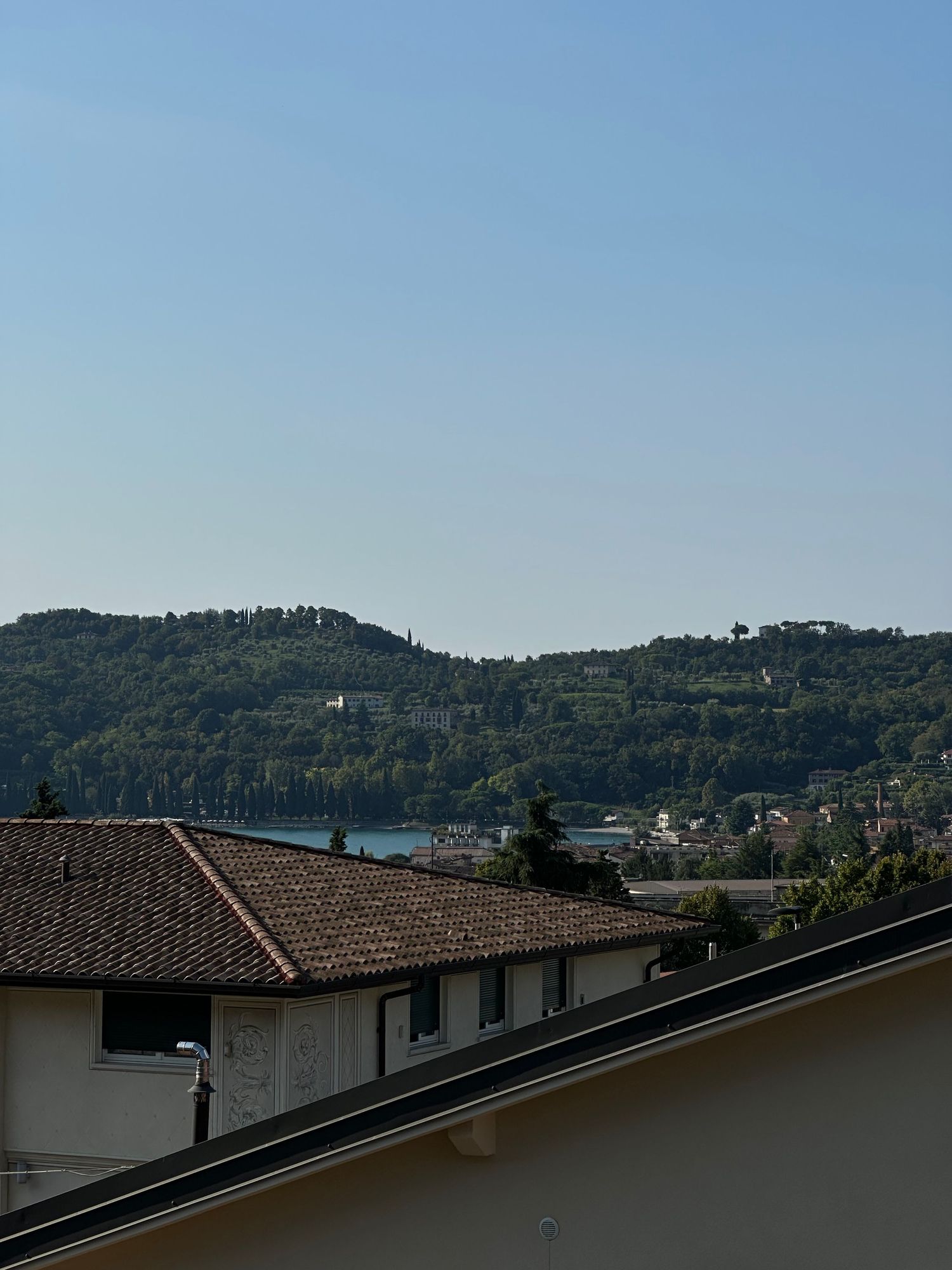 Panoramic view of hillside houses and rooftops against a blue sky.
