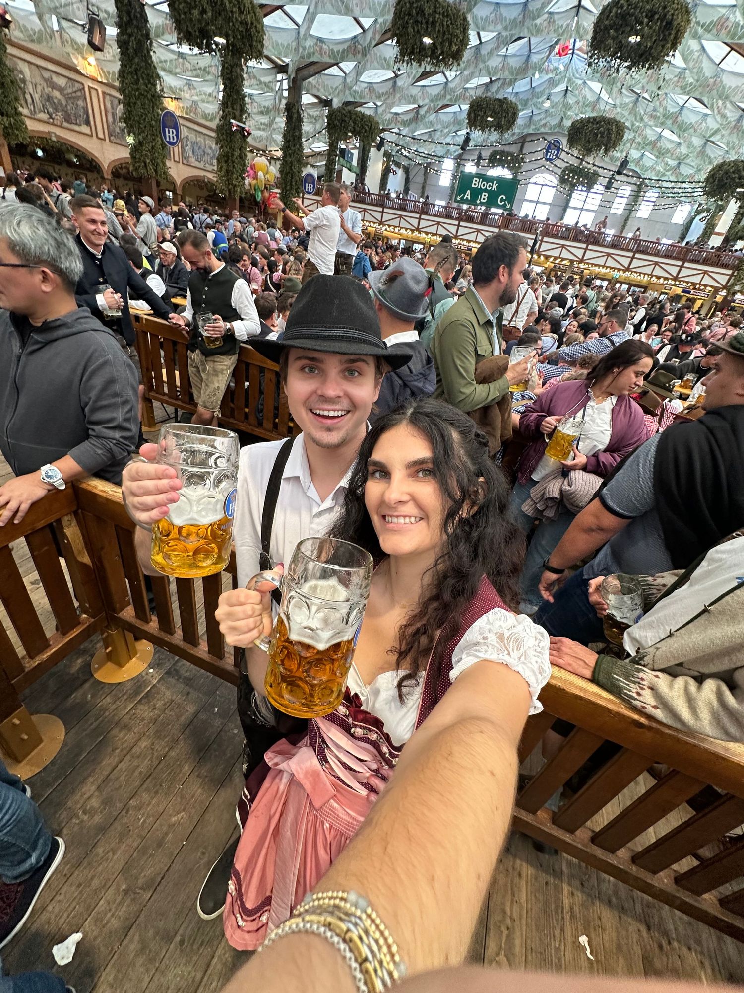 Traditional beer hall scene with wooden tables and festive decorations overhead.