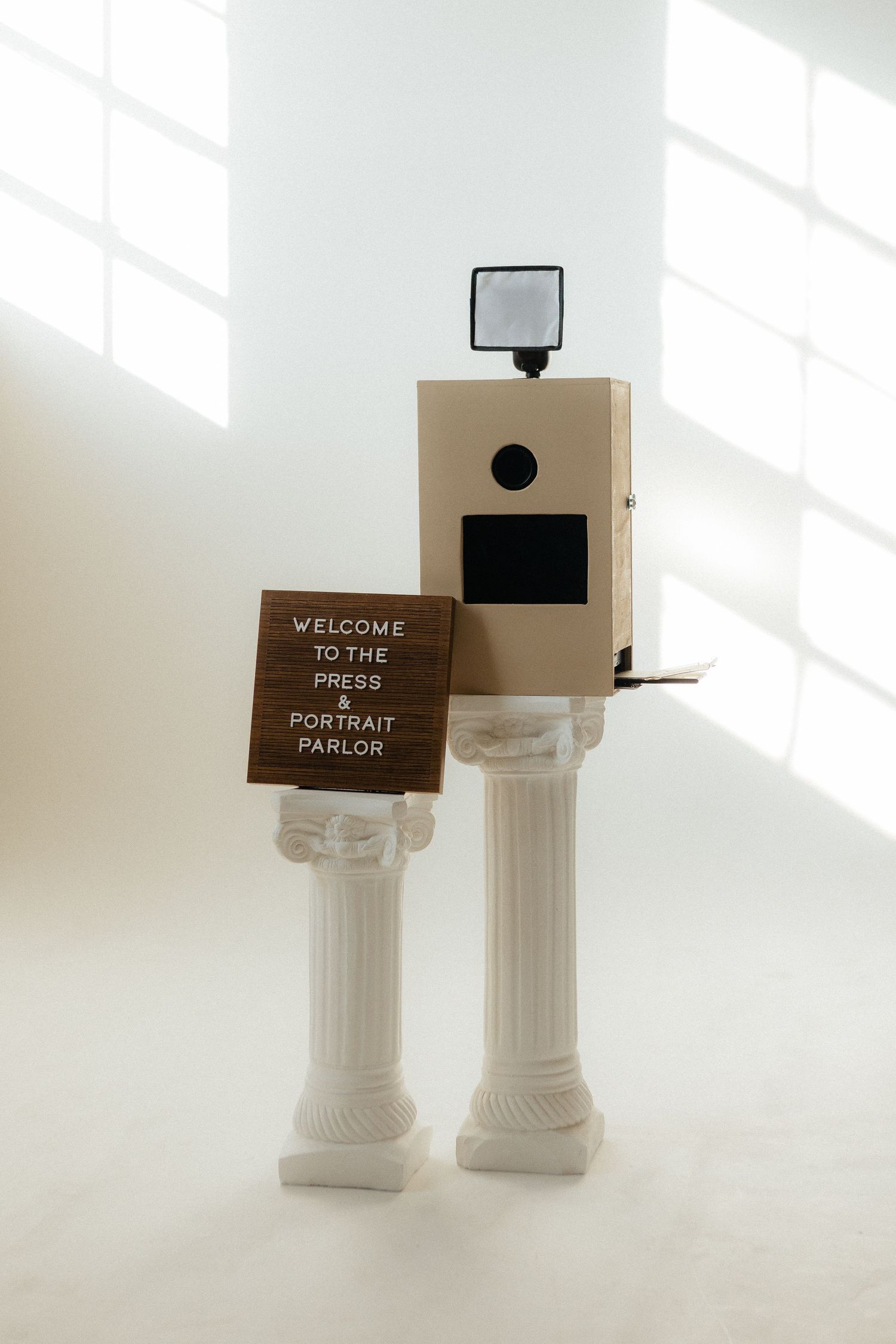 White decorative columns with brown welcome signs in bright interior space.