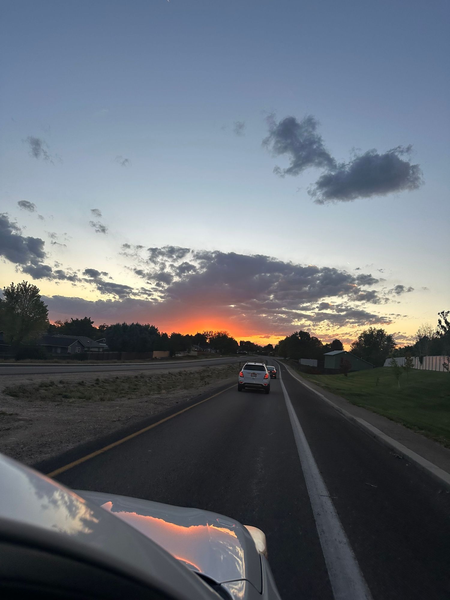 Sequence of sunset photos showing orange sky and clouds along a rural road.