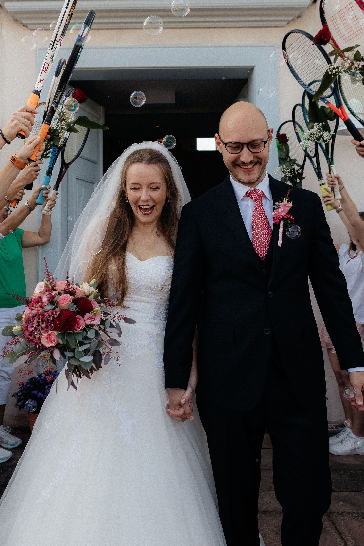 Joyful wedding celebration with bubbles as newlyweds exit their ceremony.