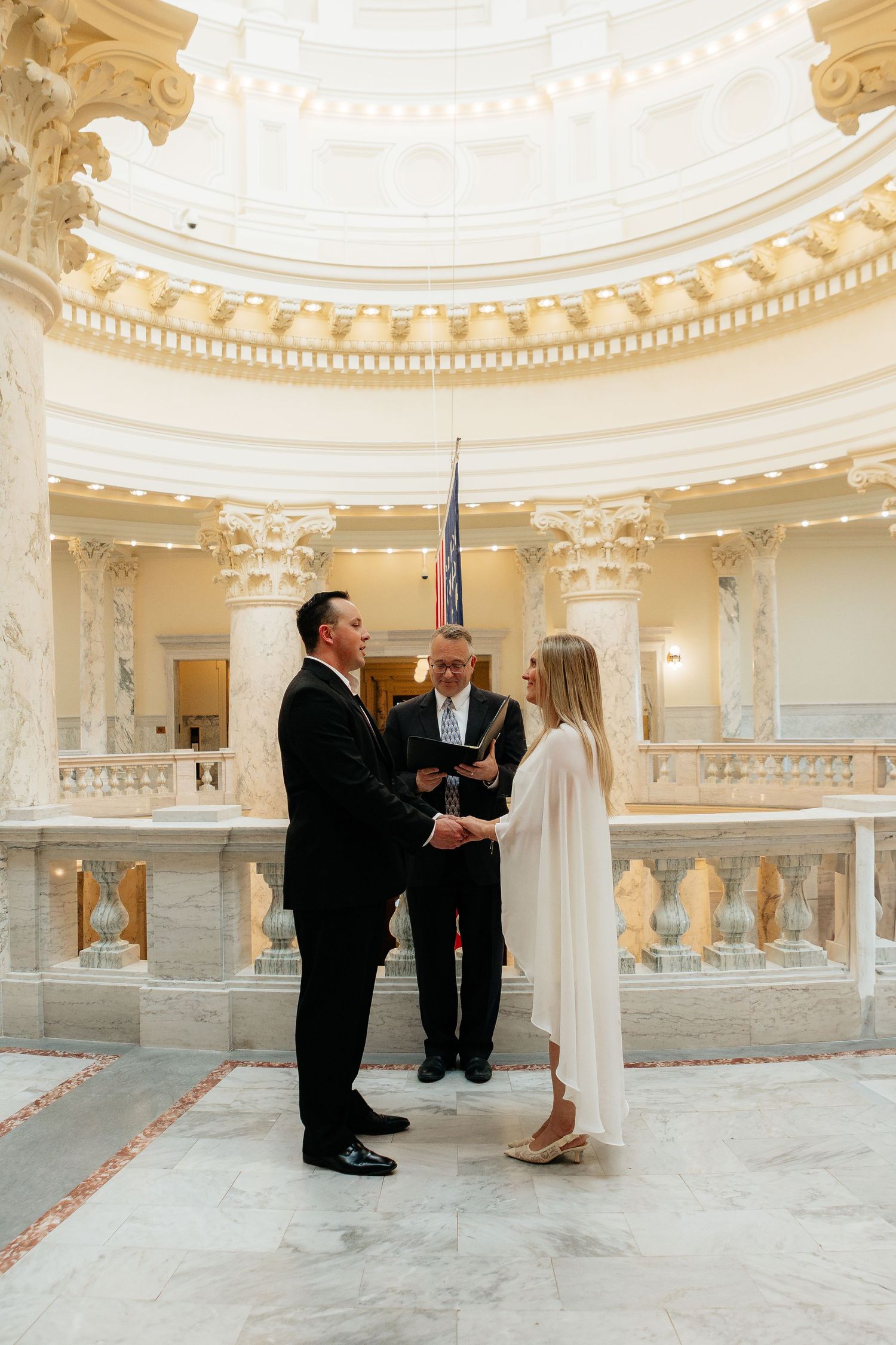 Elegant white rotunda interior with ornate architectural details and columns.