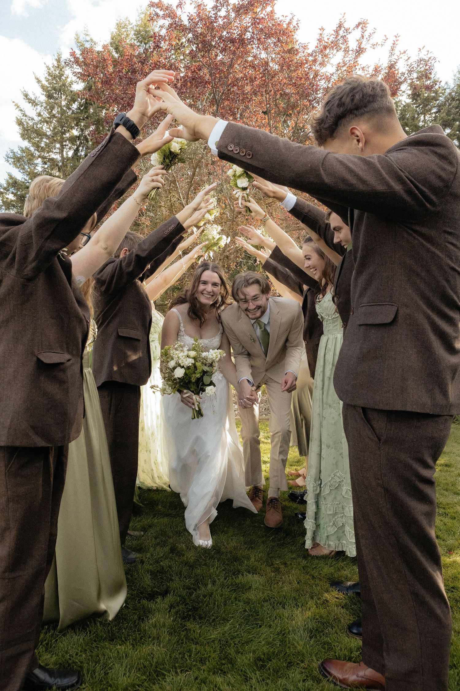 Wedding party performing synchronized dance moves outdoors in autumn setting.