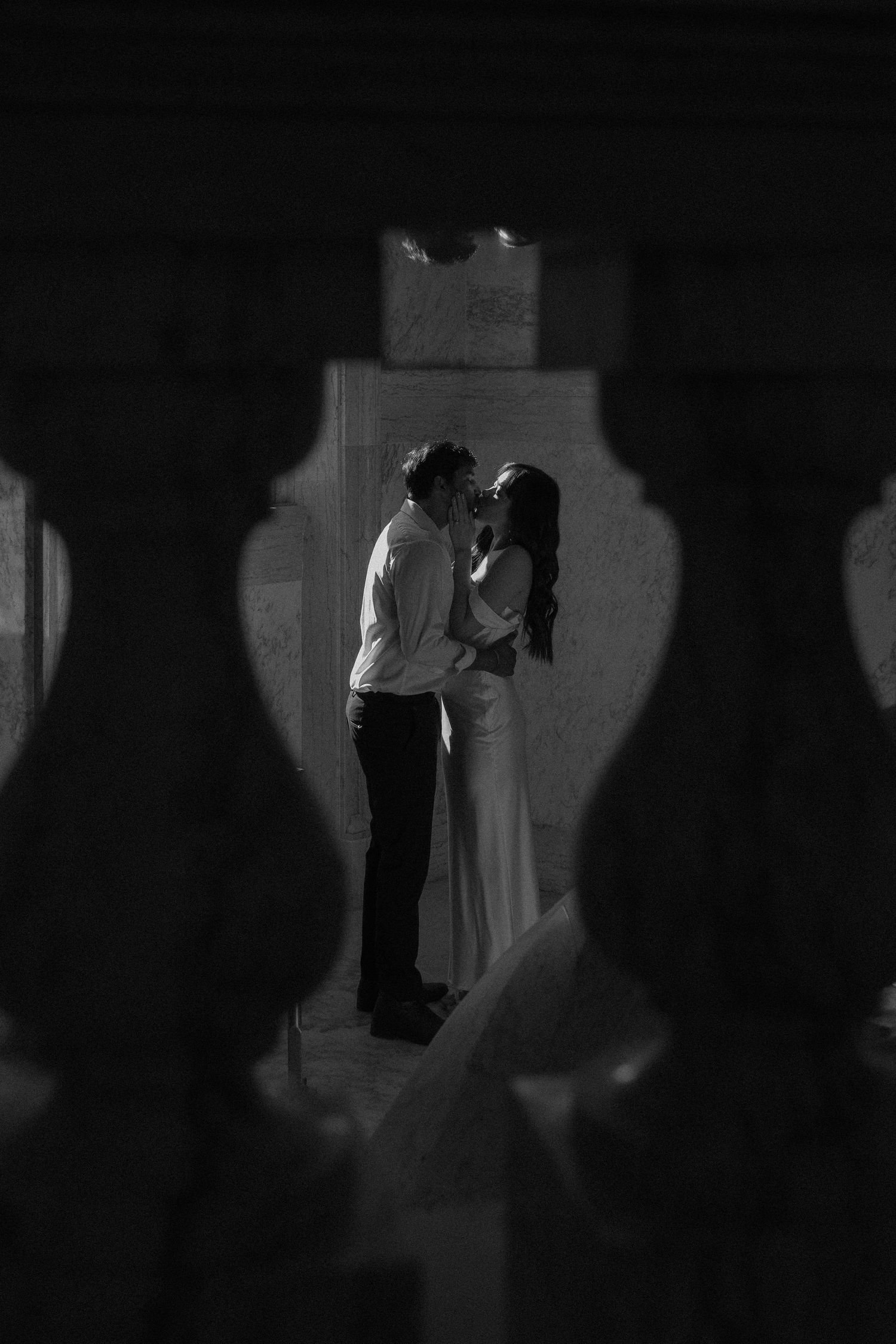 Silhouettes of wedding guests dancing at dimly lit reception.