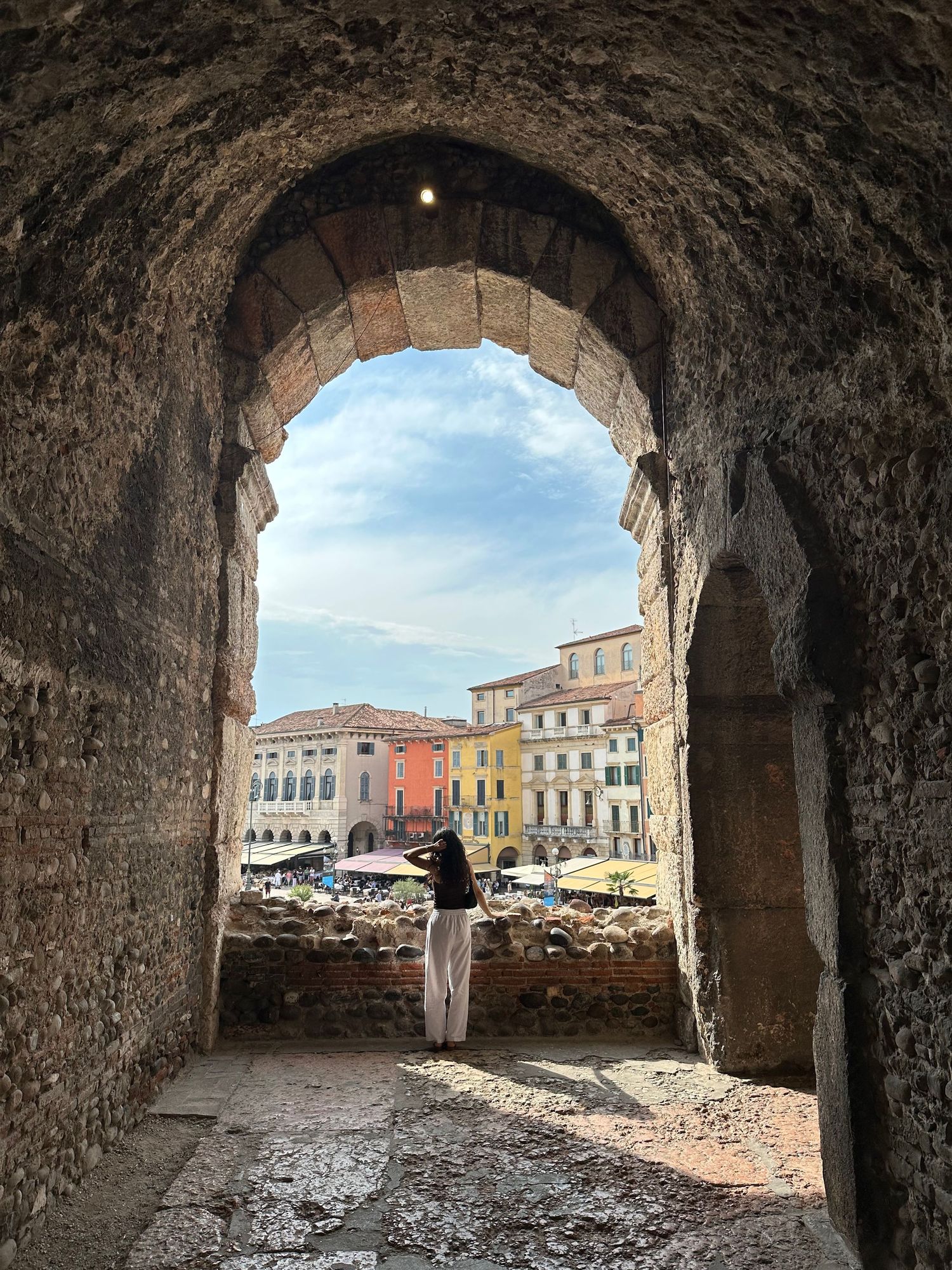 View through stone archways overlooking a historic European town square.