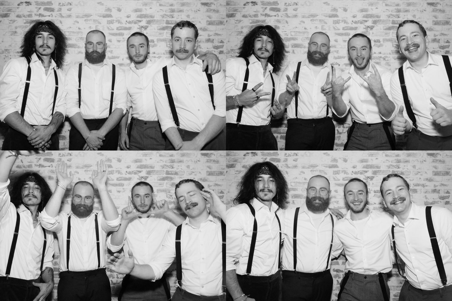 Black and white photo of a wedding party in matching white shirts and suspenders posing against a brick wall.