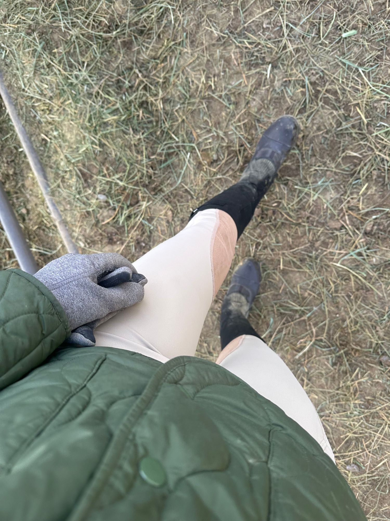 Feet resting on grass wearing grey socks and green pants.