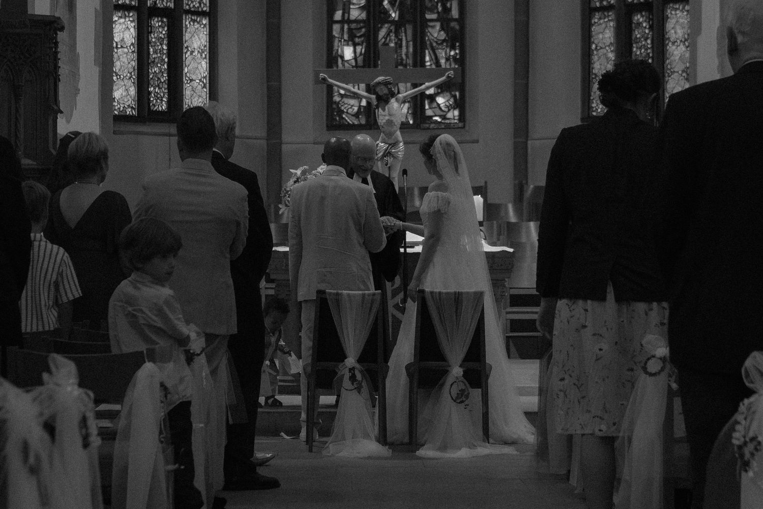 Dark monochrome interior shots of wedding ceremony in progress.