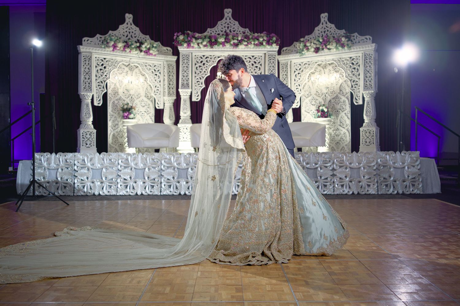 Elegant wedding reception venue with illuminated white decor and dance floor setup for an evening celebration.