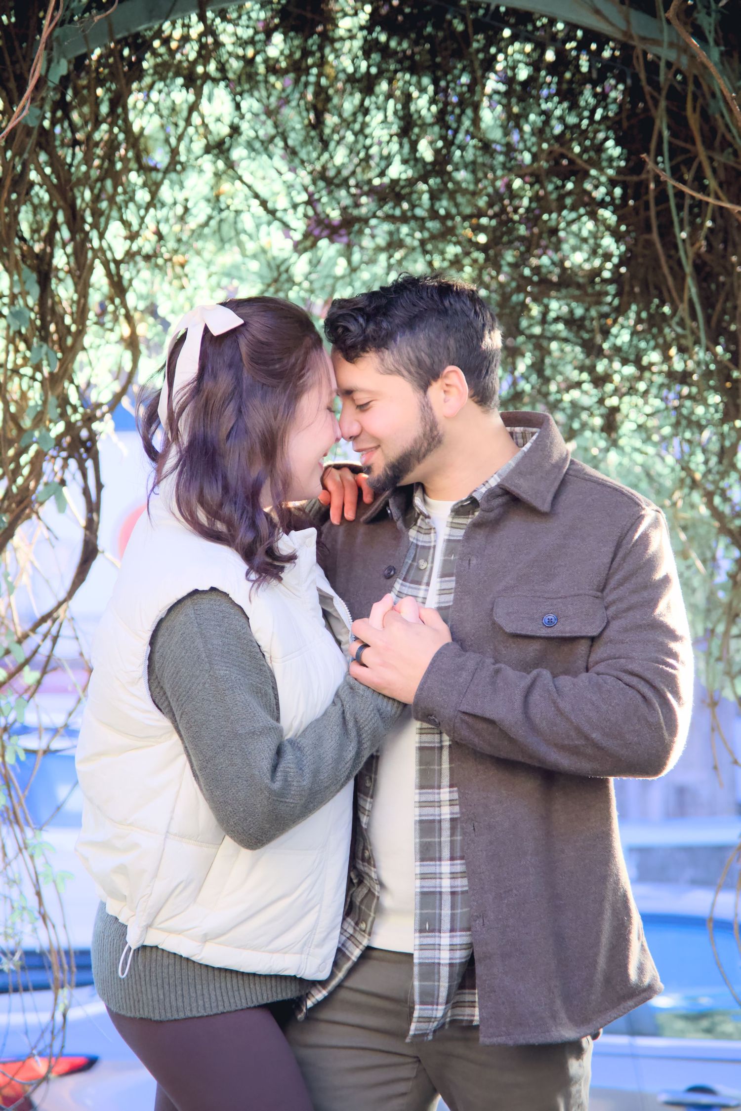 Romantic outdoor photoshoot under a tree canopy with natural lighting.