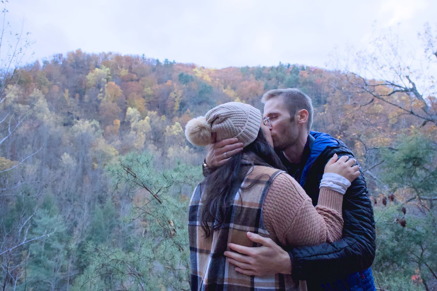 A couple embraces while enjoying autumn mountain views together.