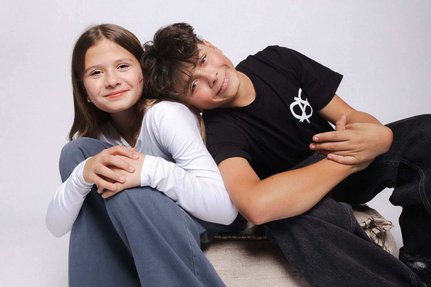 Family portrait session with casual poses against white backdrop.