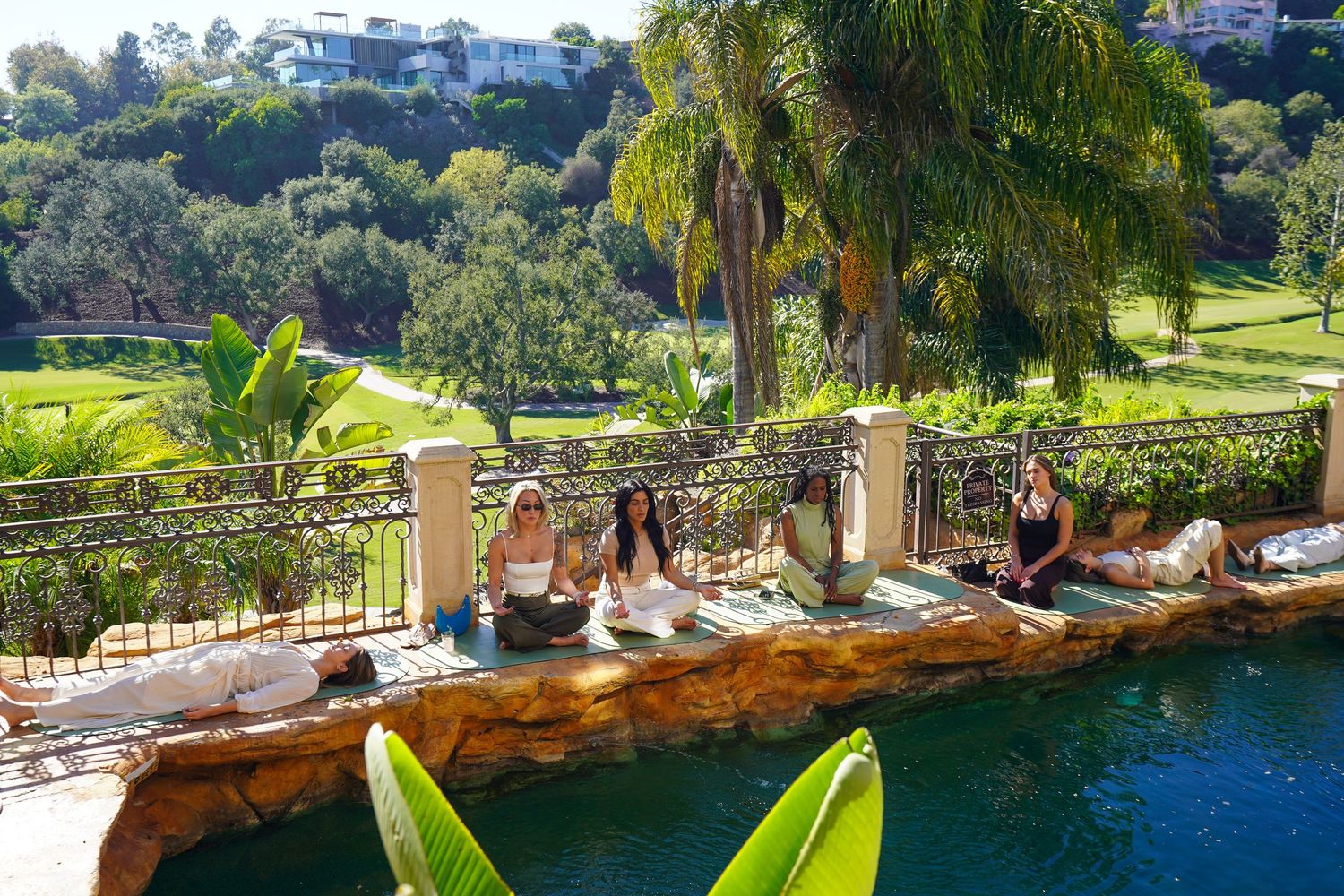 Luxury poolside setting with palm trees and ocean views at an upscale resort.