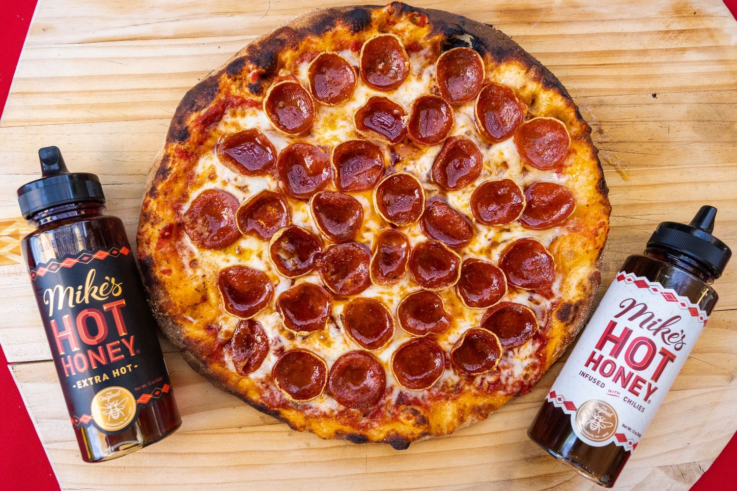 Pepperoni pizza with perfectly melted cheese and crispy crust displayed with drink bottles.