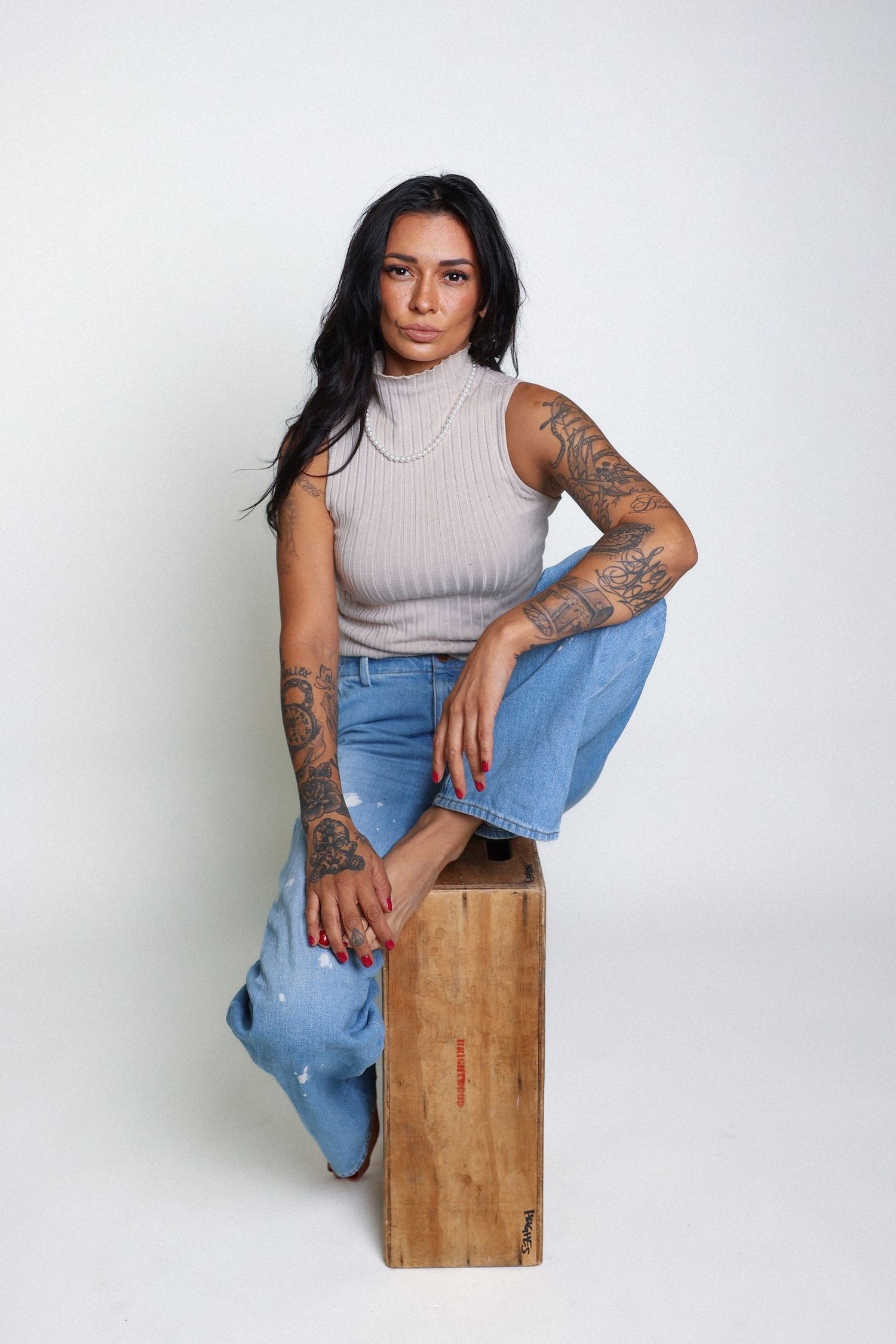 Minimalist studio portraits with casual styling and wooden prop elements.